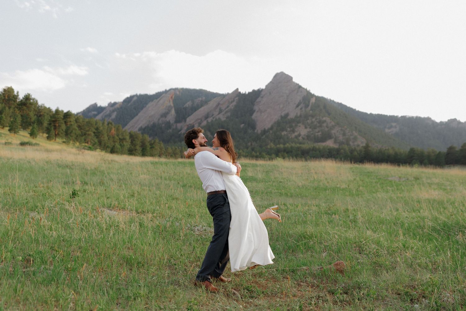 Engaged couple embracing in a mountain meadow during an intimate engagement photography session