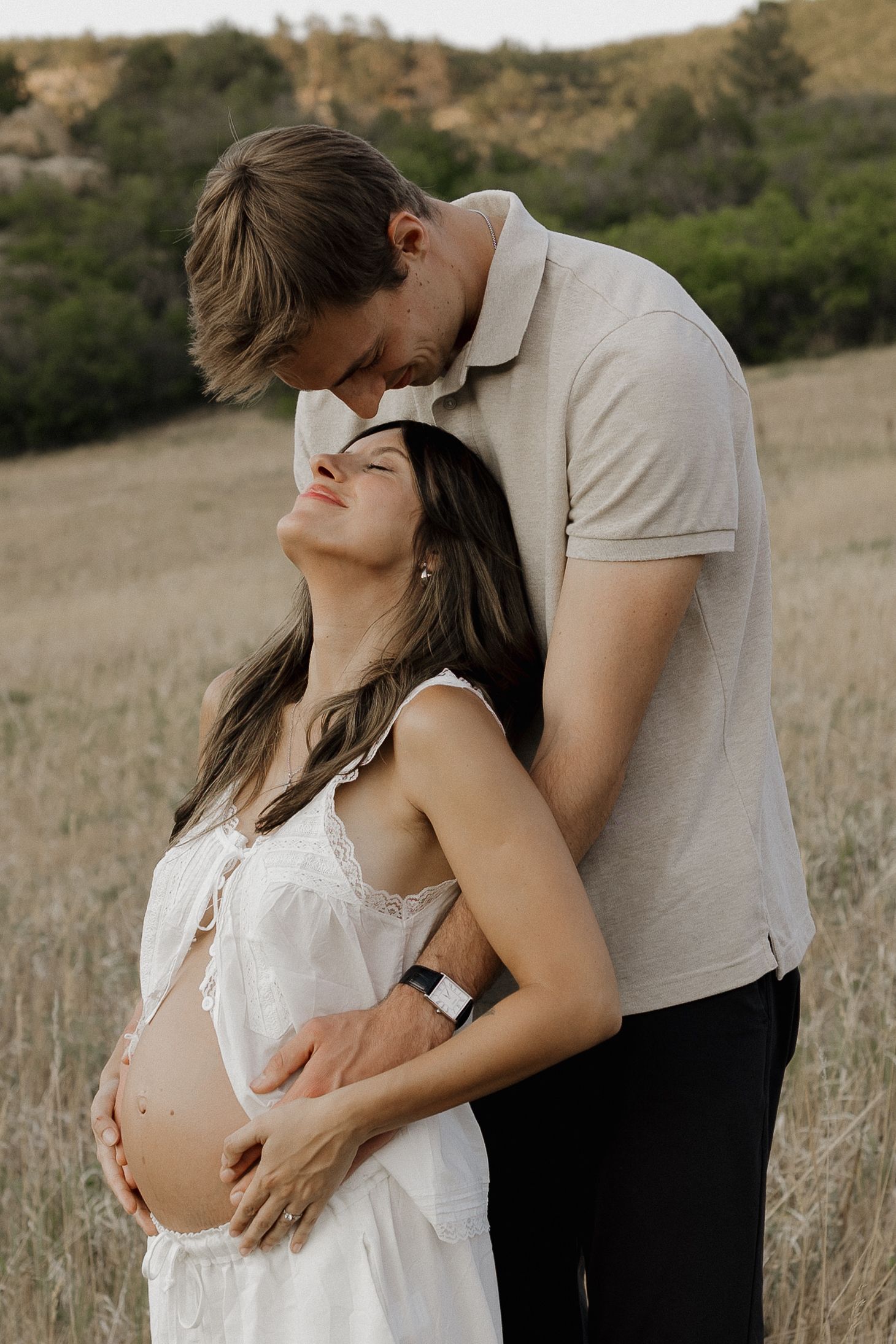Expectant couple sharing a tender moment together during a natural maternity photography session