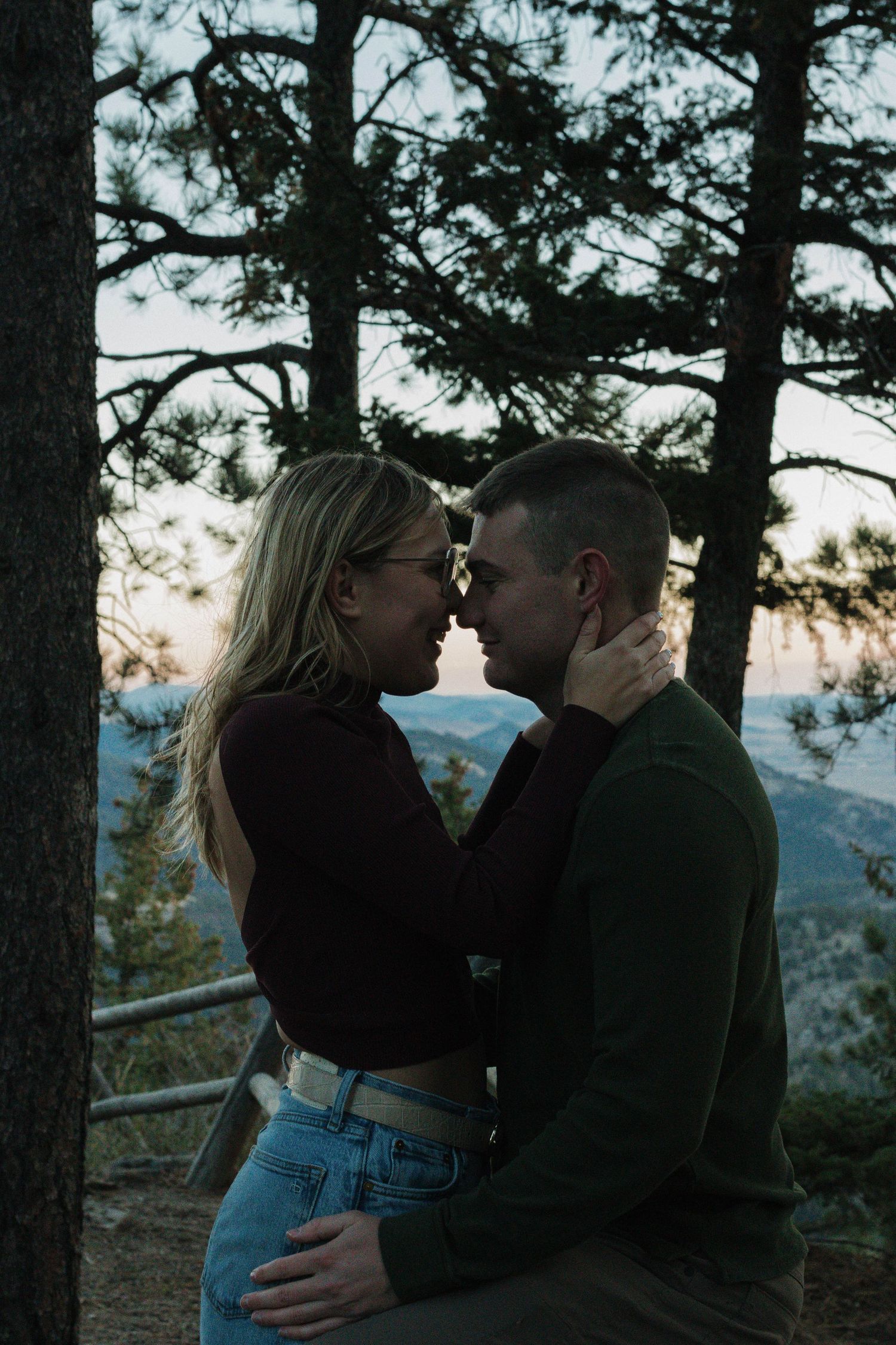 Couple sharing an intimate moment outdoors among the trees during a natural couples photography session