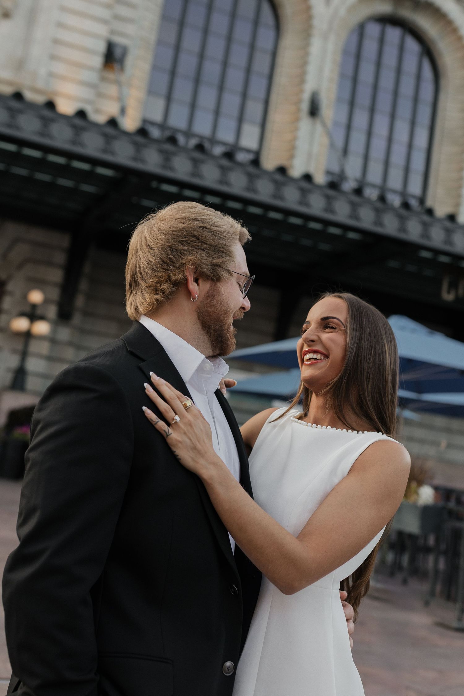Couple laughing together outside Union Station during an urban couples session