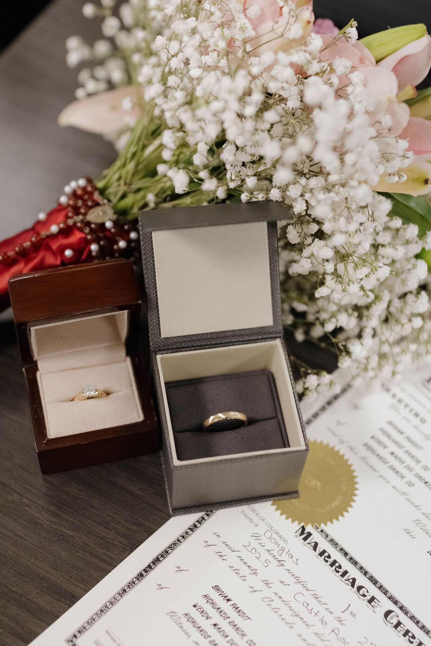 Engagement ring and jewelry photographed with delicate flowers and invitation details