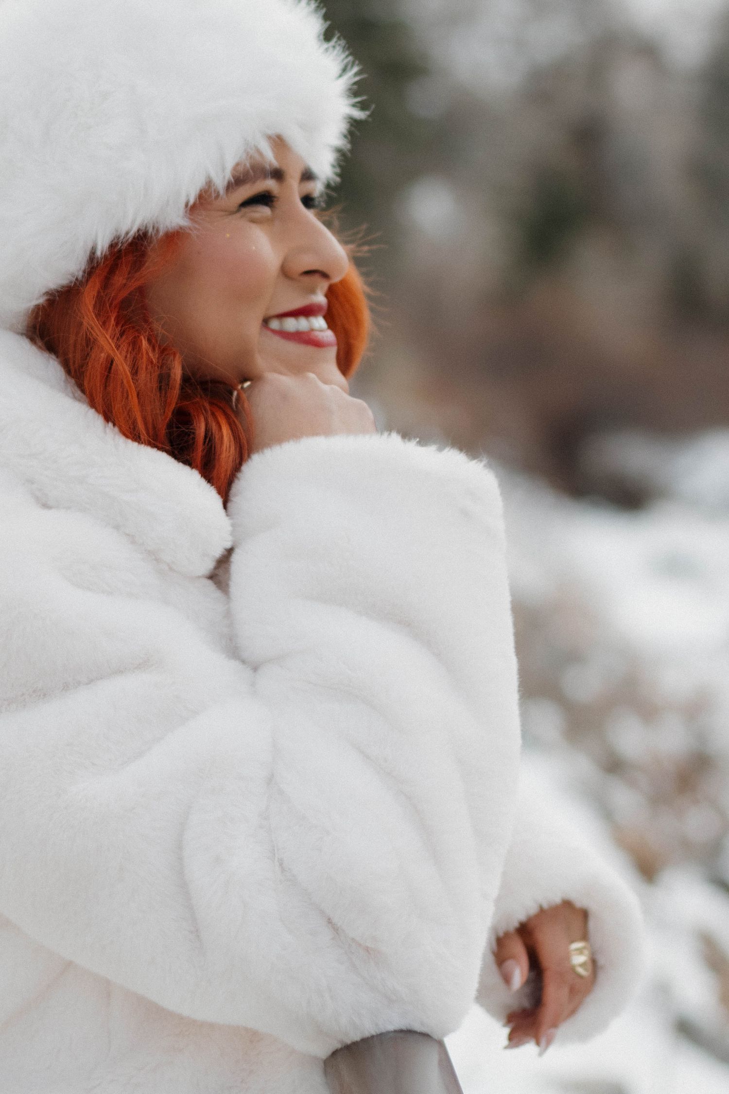 Woman wearing a cozy white winter hat and sweater during an intimate outdoor portrait photography session
