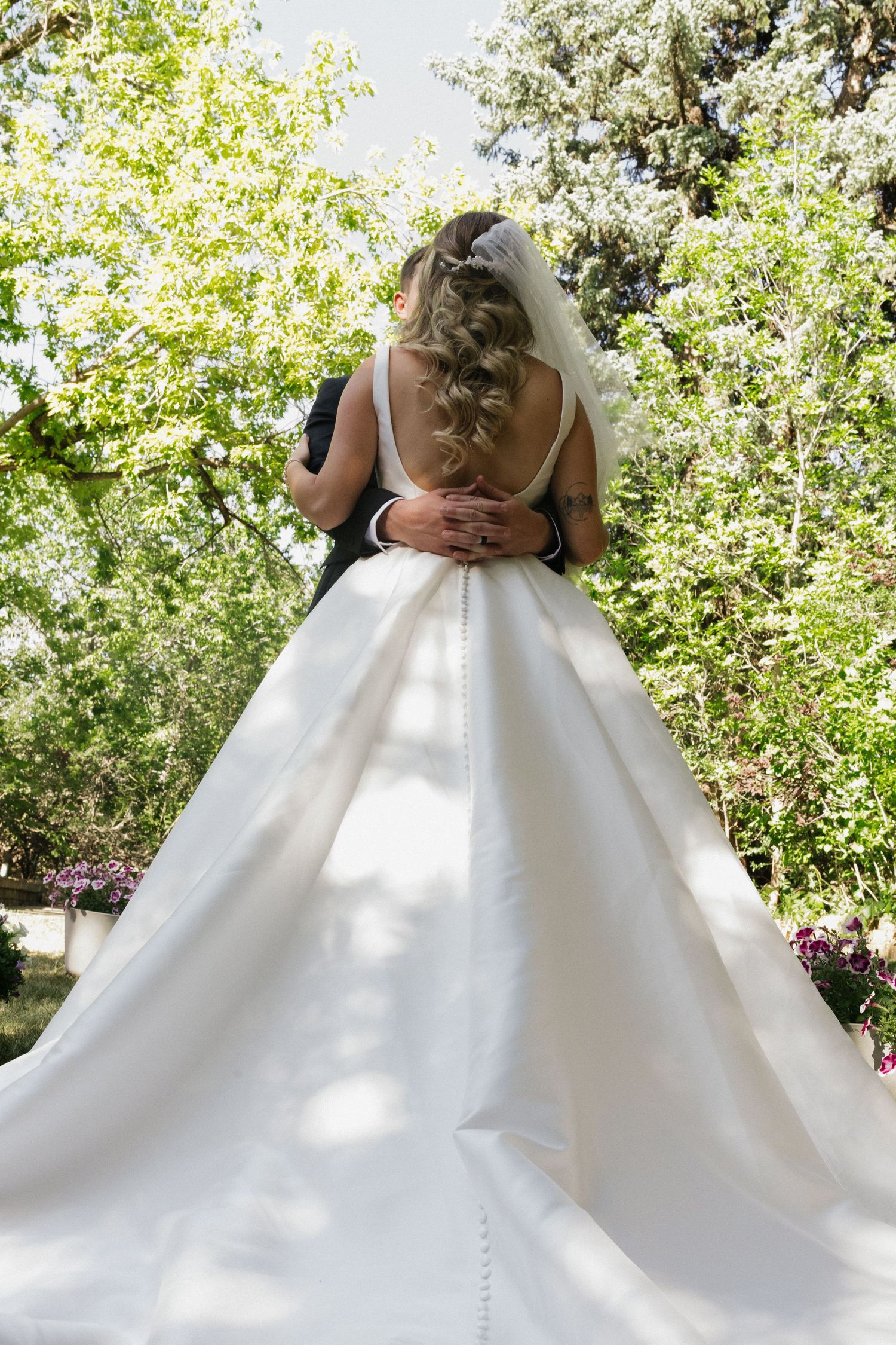 Bride walking outdoors in her wedding dress surrounded by trees on her wedding day