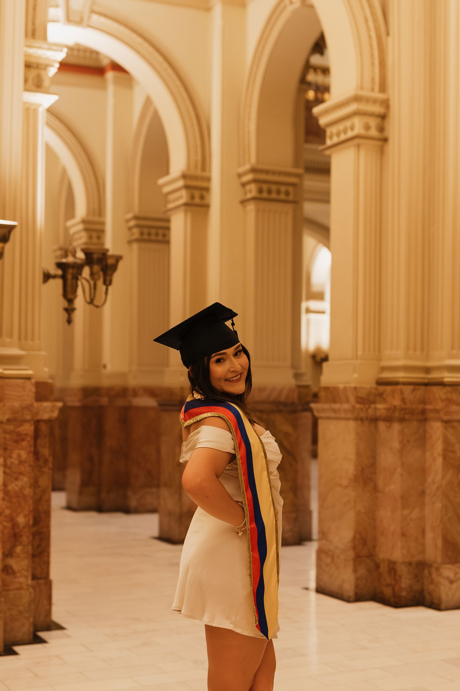 Graduation portrait of a woman in a light dress