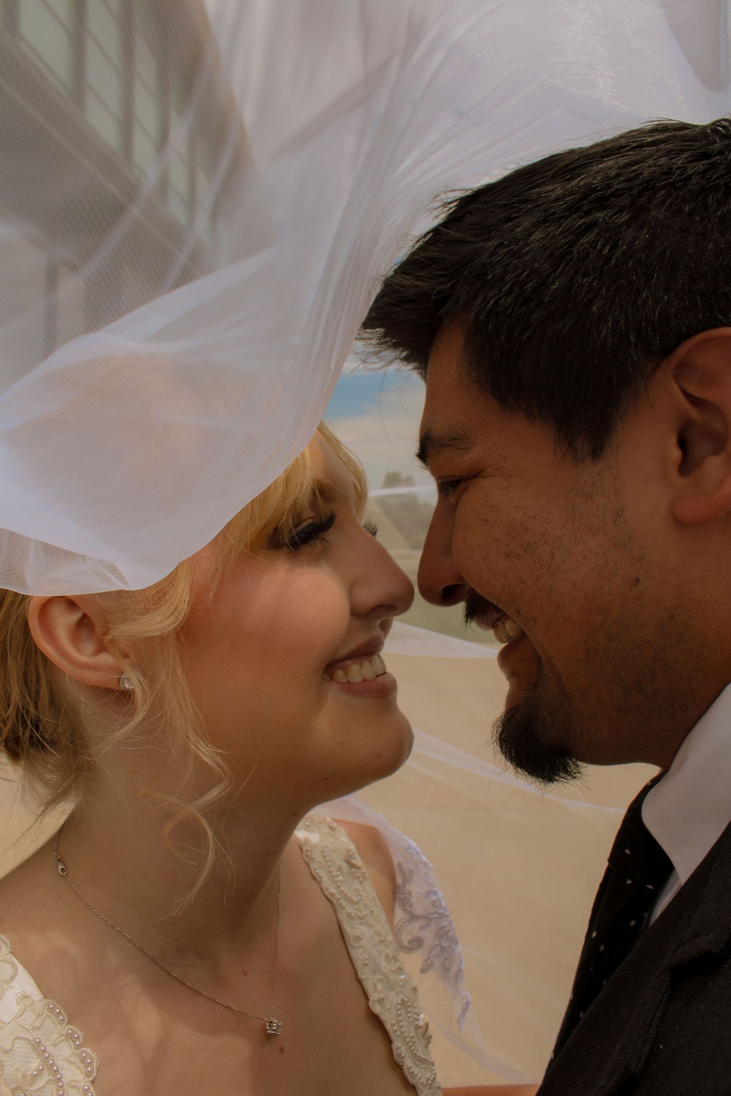Bride and groom standing outdoors with their officiant during their wedding ceremony