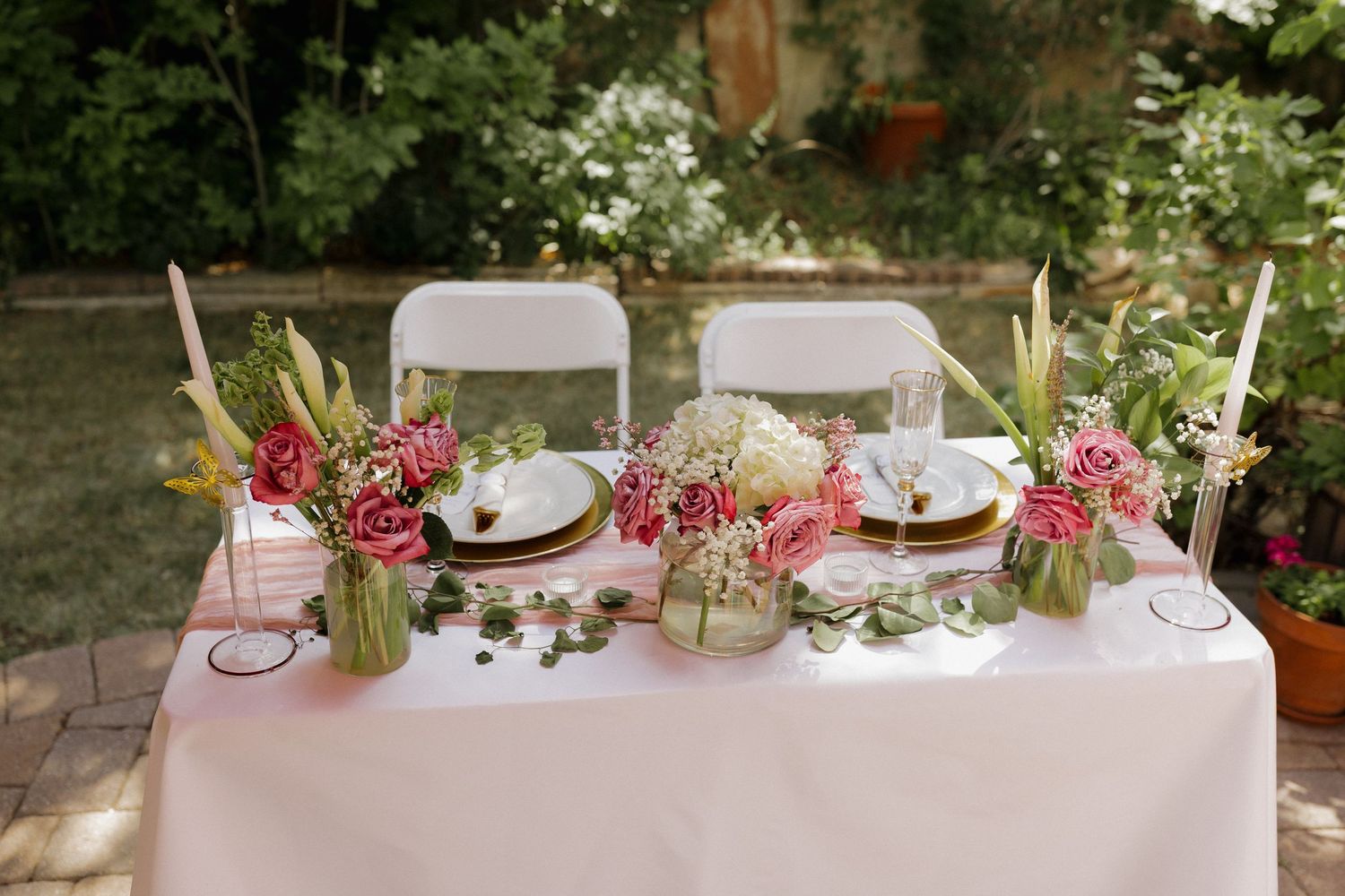 Outdoor wedding reception table beautifully decorated with floral arrangements and elegant place settings