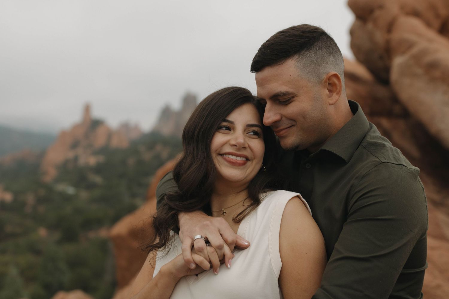 Couple embracing and smiling together in a scenic outdoor setting during a warm and natural couples photography session