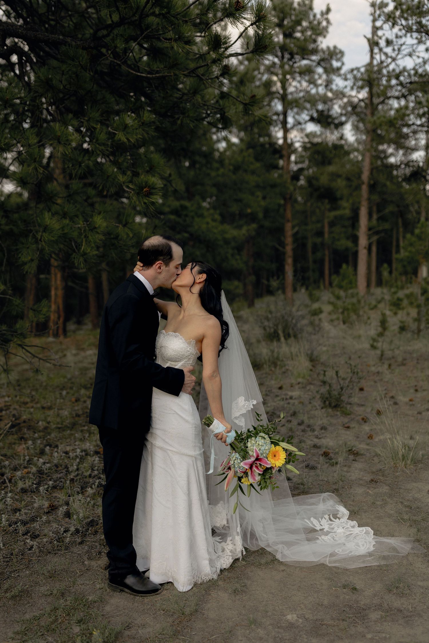 Bride and groom sharing a kiss outdoors after their wedding ceremony