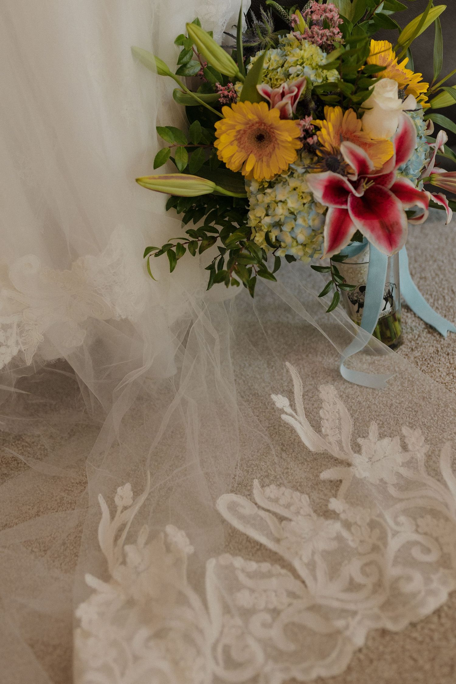 Colorful wedding bouquet resting on a flowing bridal veil