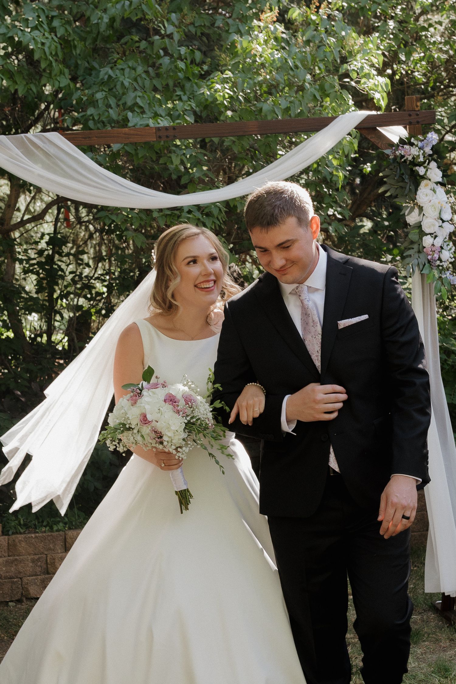 Newlywed couple walking together outdoors after their wedding ceremony