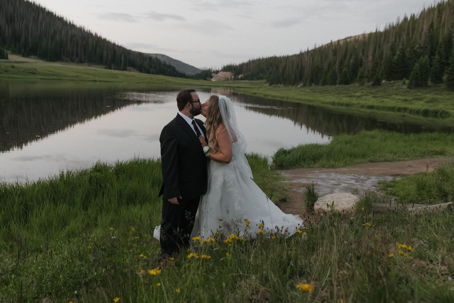 Newlywed couple walking through a meadow at golden hour in Colorado