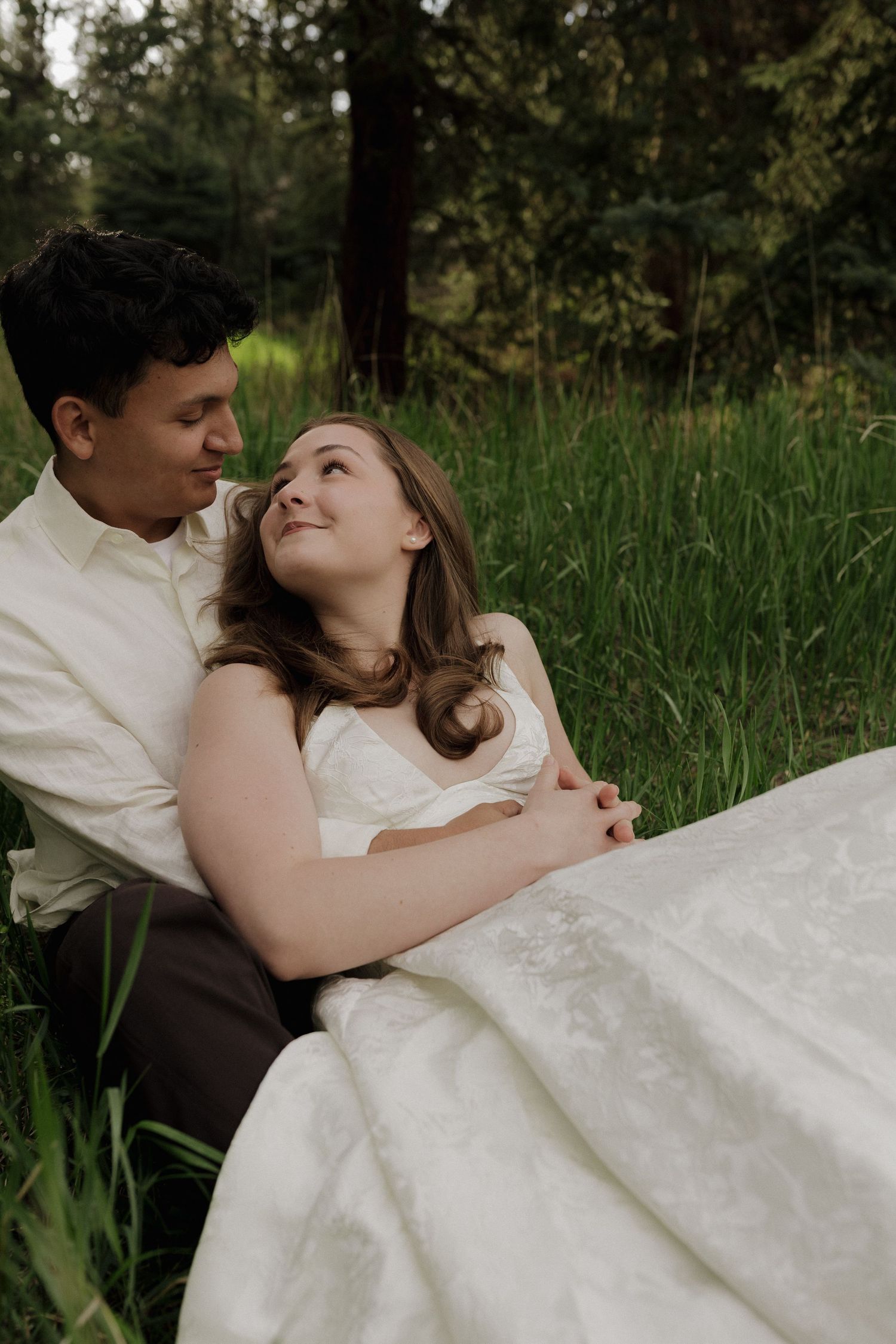Couple sitting together outdoors, sharing a quiet and intimate moment during a couples photography session