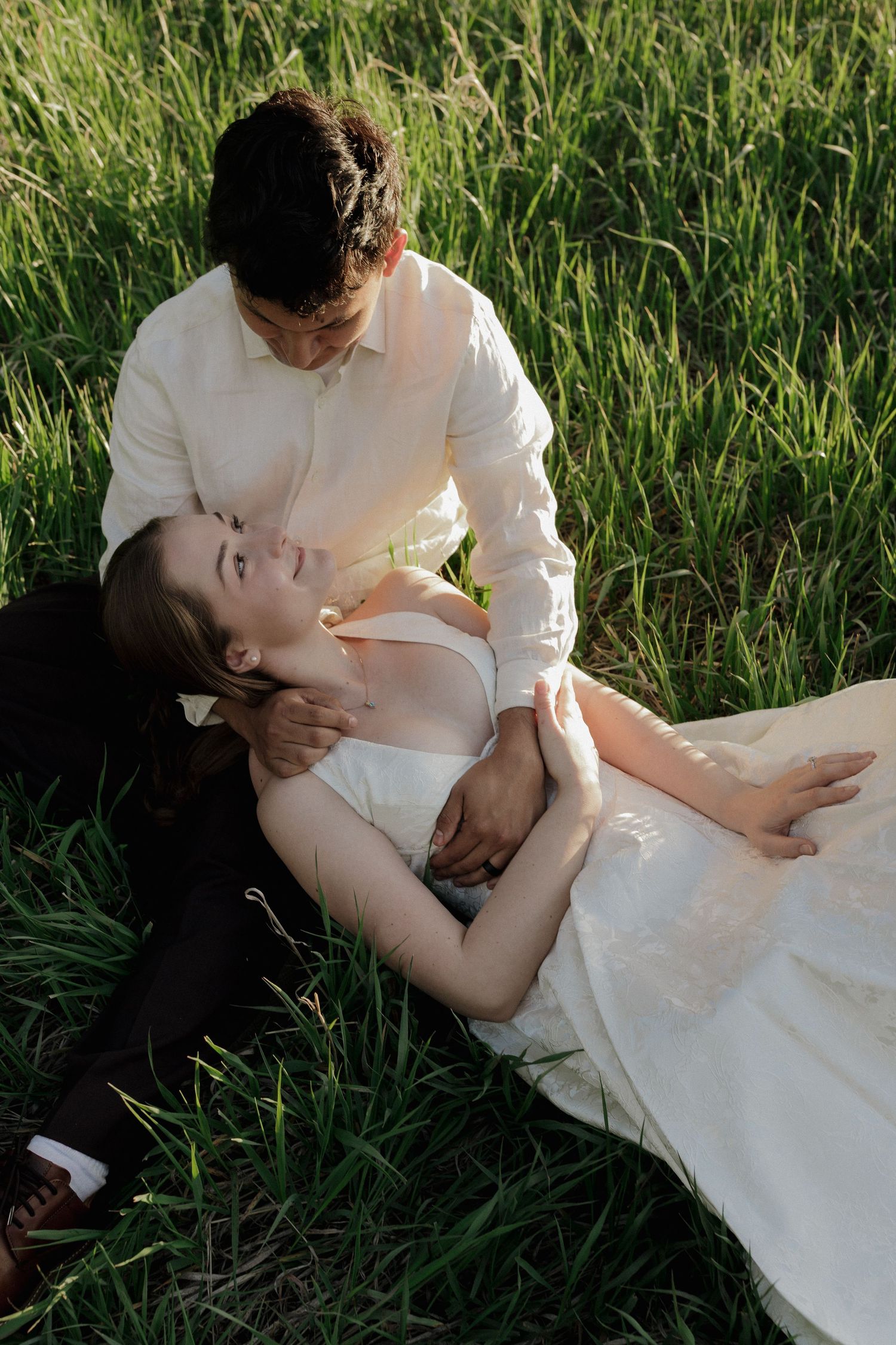 Couple sharing an intimate moment together in a sunlit meadow during a natural couples photography session