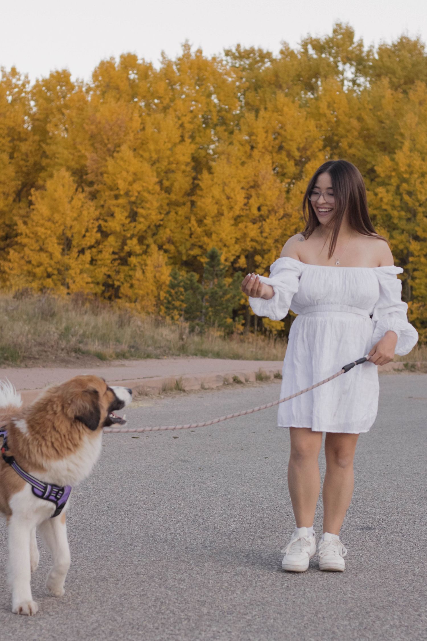 Woman with her dog walking in autumn during a natural portrait photography session