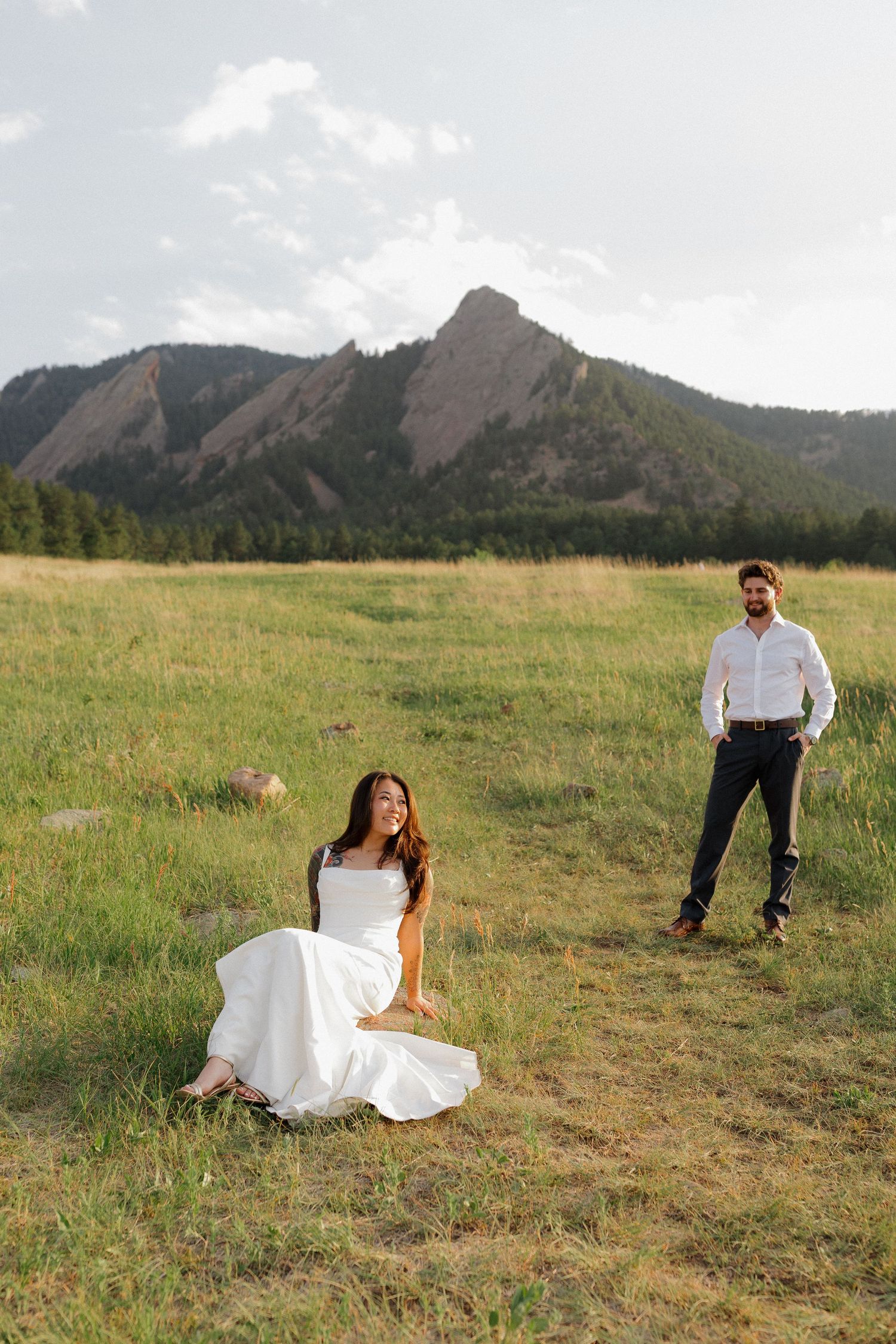 Couple enjoying a playful moment in a wide mountain meadow during an adventurous outdoor couples photography session
