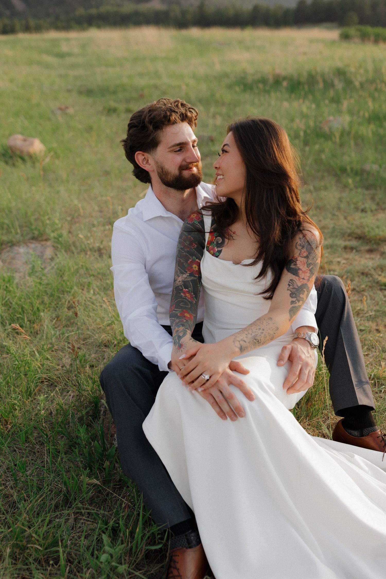 Engaged couple sitting together in a mountain meadow during an intimate outdoor engagement photography session
