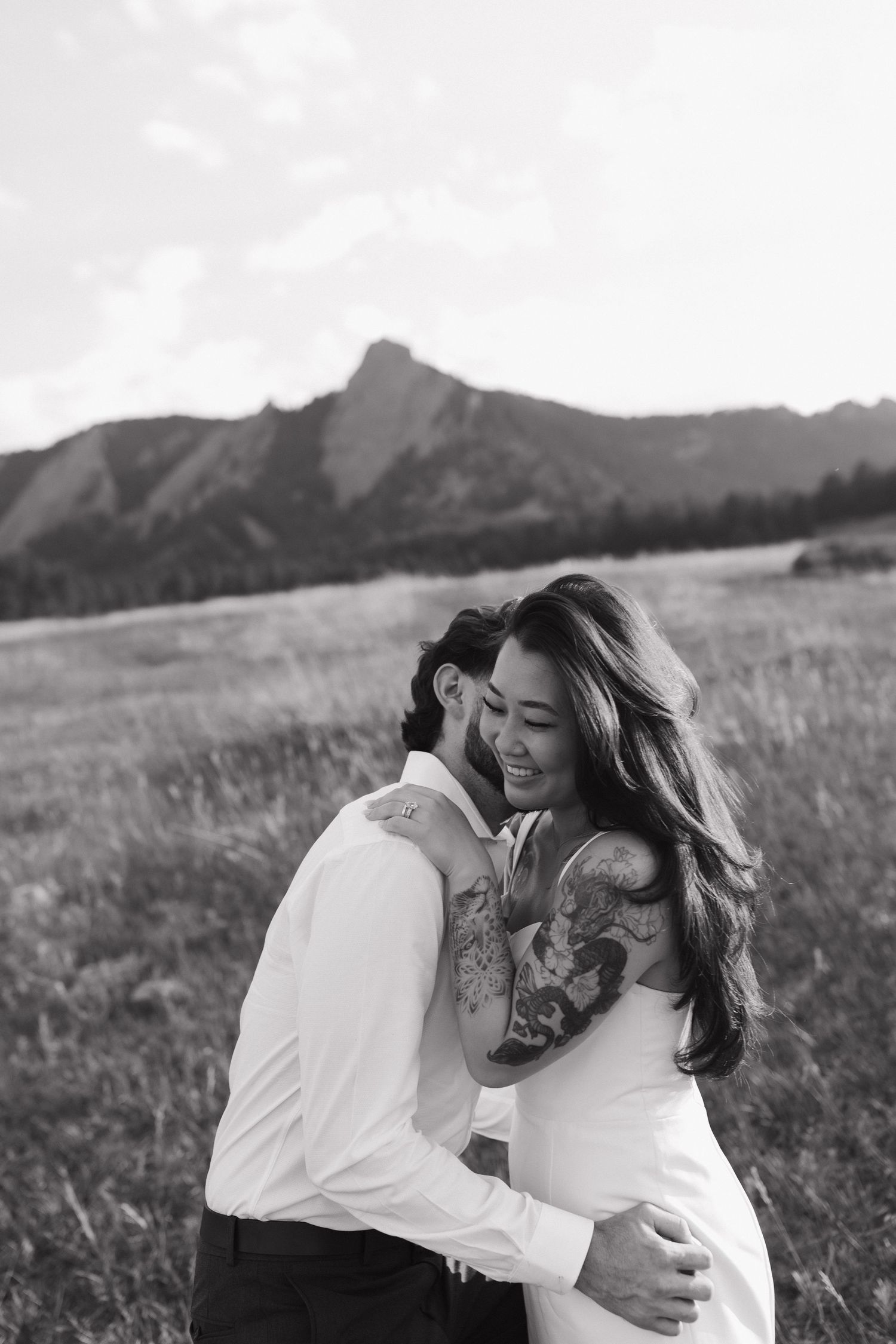 Couple embracing in a mountain meadow during an intimate black and white couples photography session
