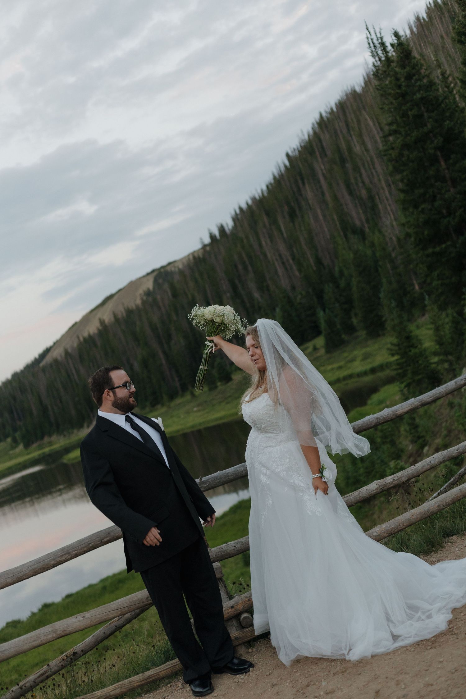 Couple walking hand in hand through a Colorado mountain meadow at sunset