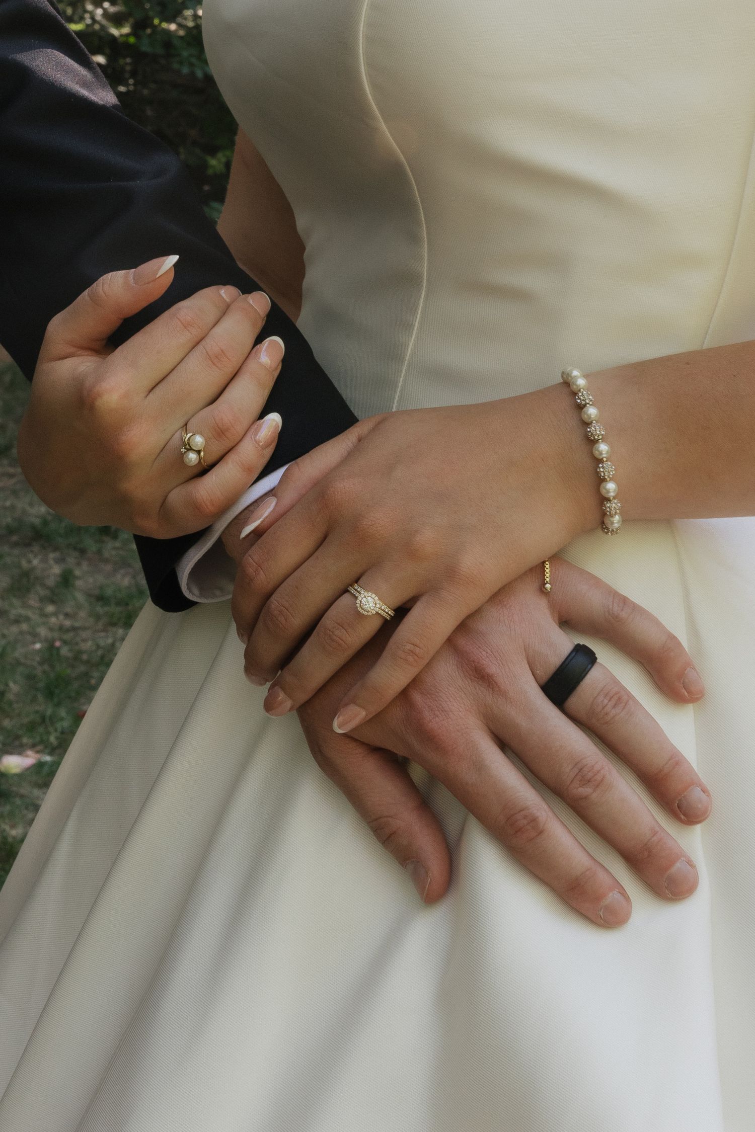 Close-up of a bride and groom holding hands, showing their wedding rings on their wedding day
