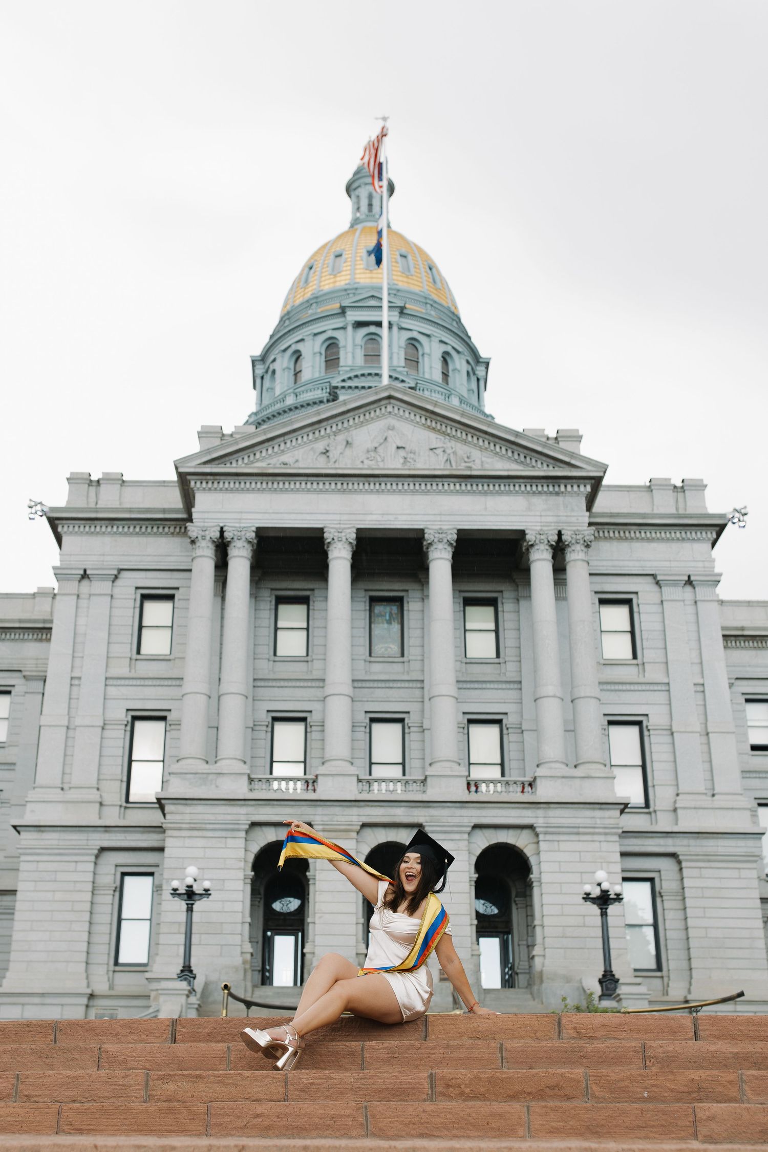 Graduate posing outside a historic building during an elegant graduation portrait session