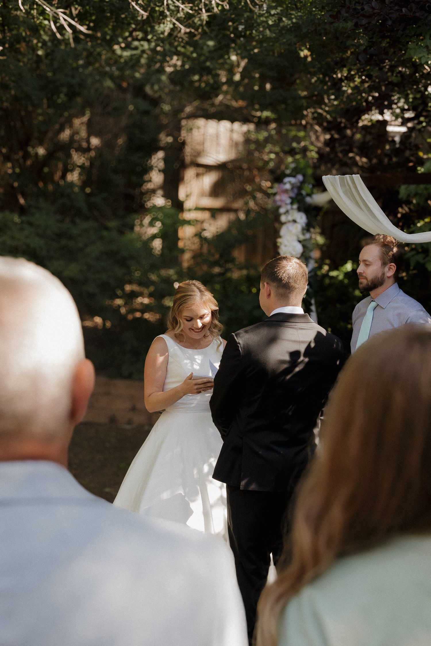 Bride smiling during an intimate wedding ceremony surrounded by mountain scenery