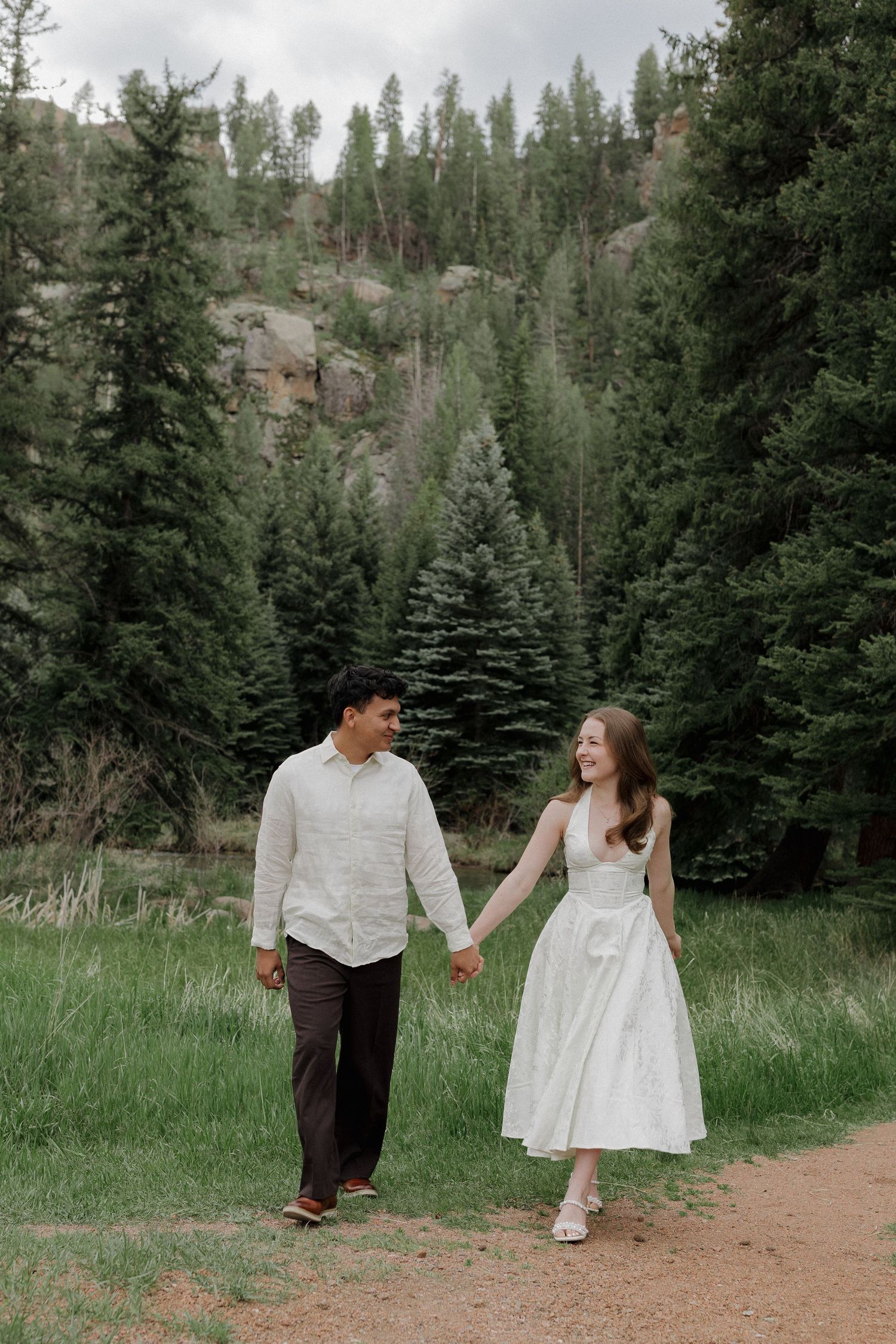 Couple walking together through a peaceful forest during a natural couples photography session