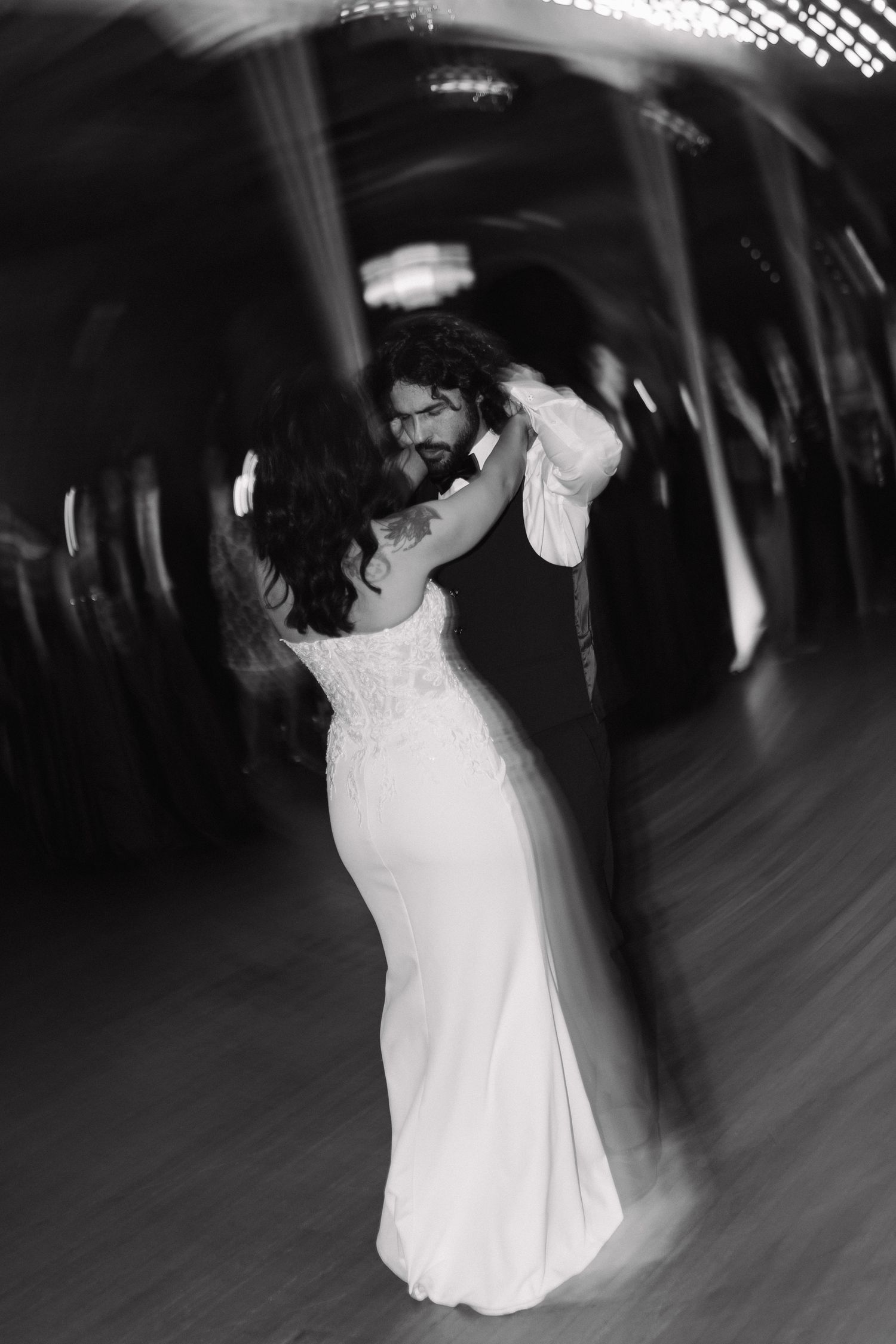 Black and white photo of bride and groom sharing romantic first dance.