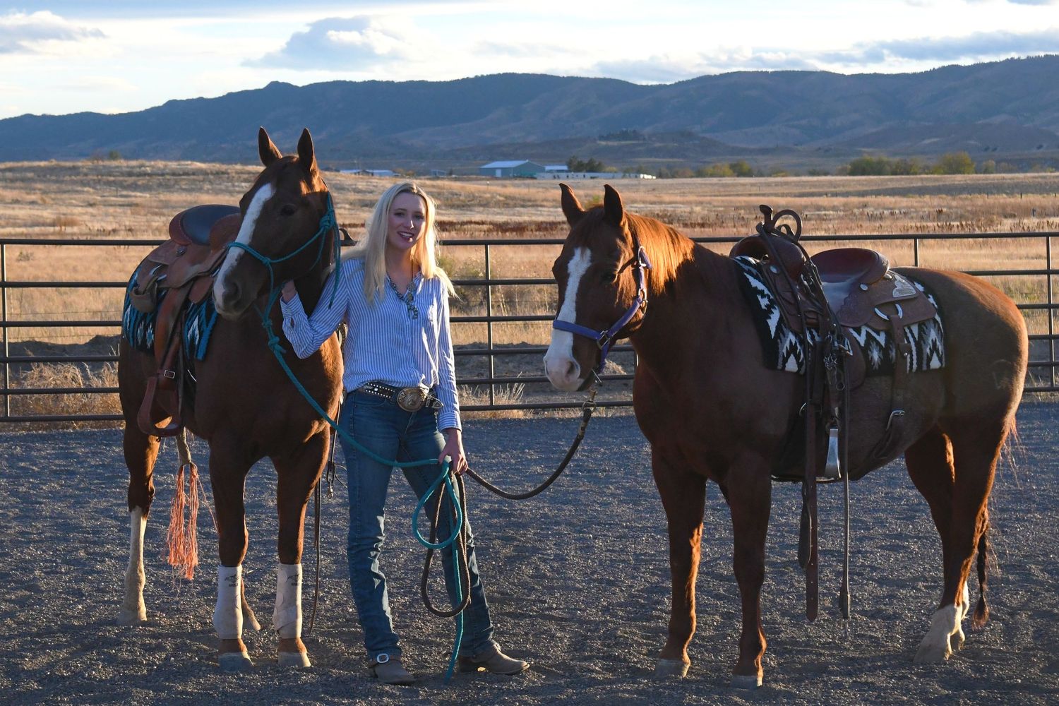 Photographer Kelsey Weir holds two horses