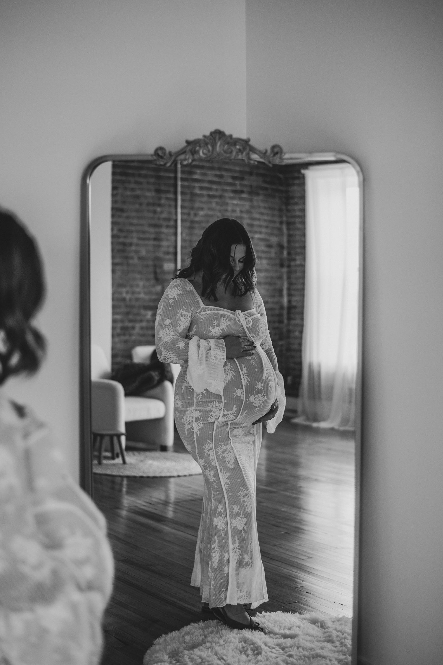 Black and white sequence of photos showing a bride in a lace wedding dress being fitted in an elegant room with hardwood floors.