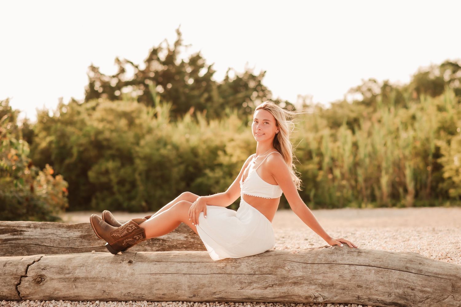 A series of sunset beach photos showing someone in a white dress reclining on sand and driftwood in warm golden light.