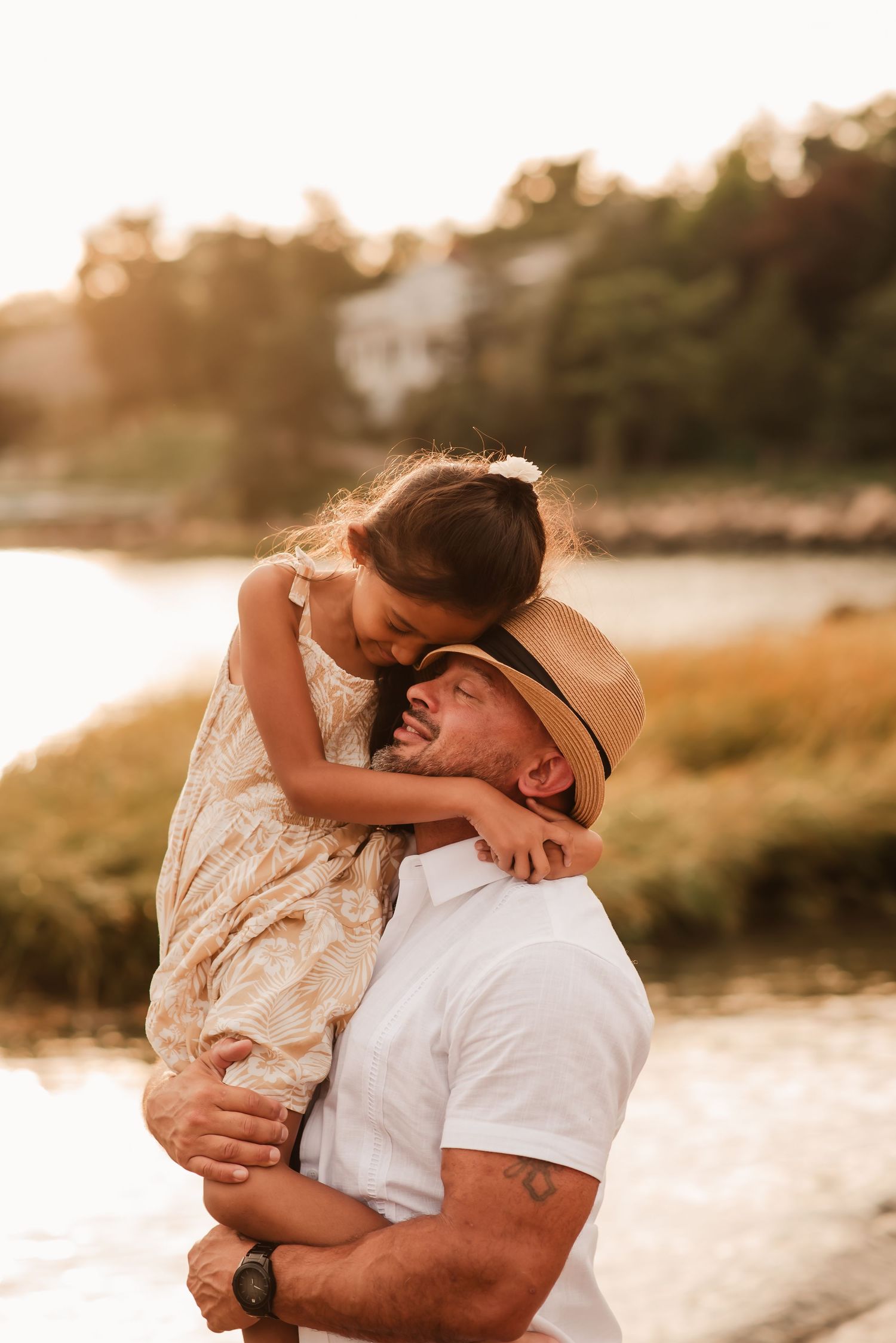 A couple embraces tenderly on a beach at sunset, creating a romantic silhouette against the golden light.
