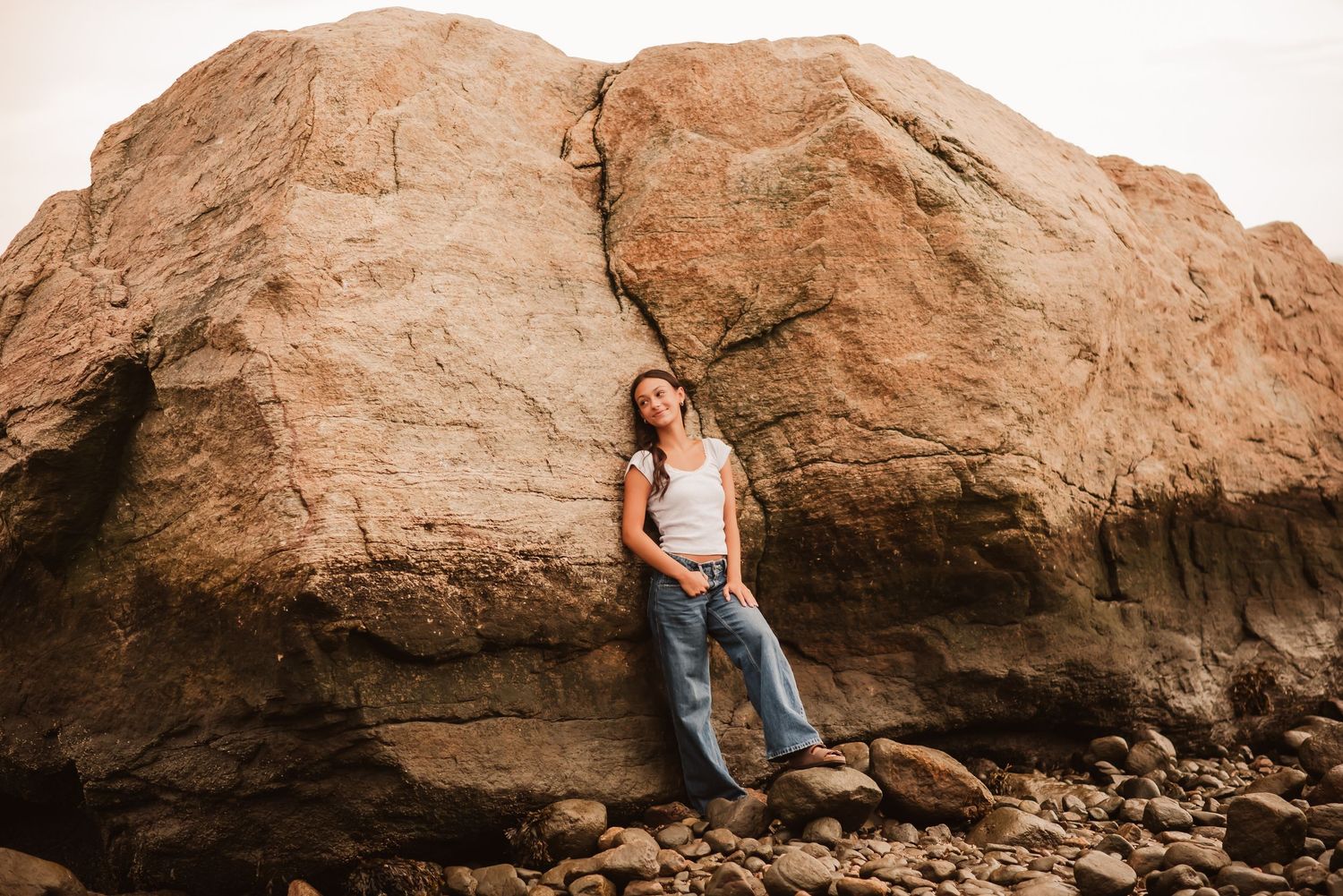 A series of artistic outdoor portraits captured against large brown rock formations in warm natural lighting.