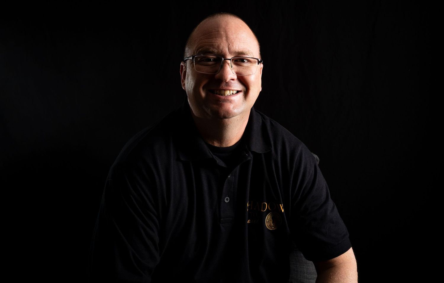 A series of six black and white headshots showing different expressions and poses against dark backgrounds.