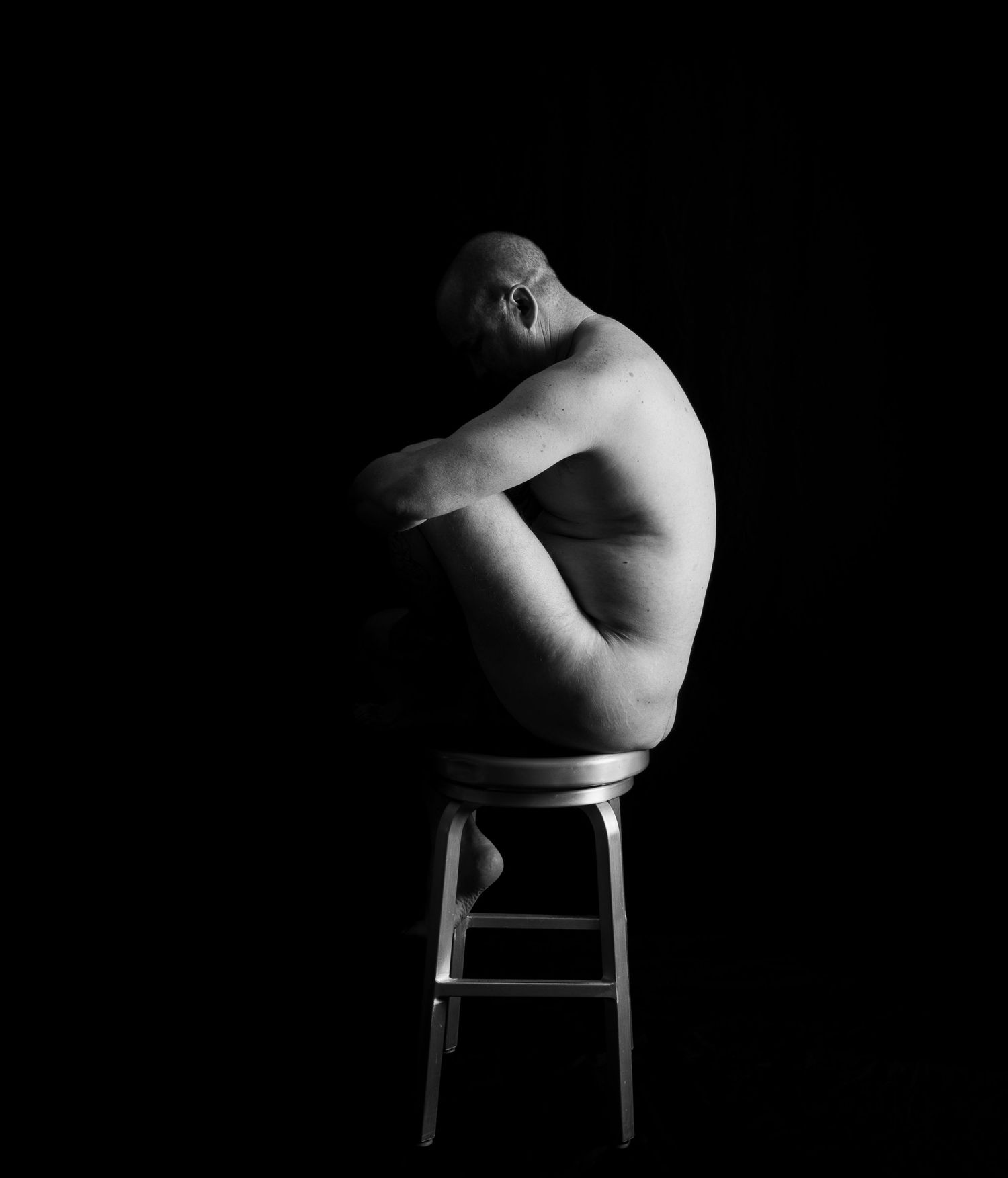 A series of artistic black and white nude maternity photographs showing a pregnant woman's silhouette against dark background.