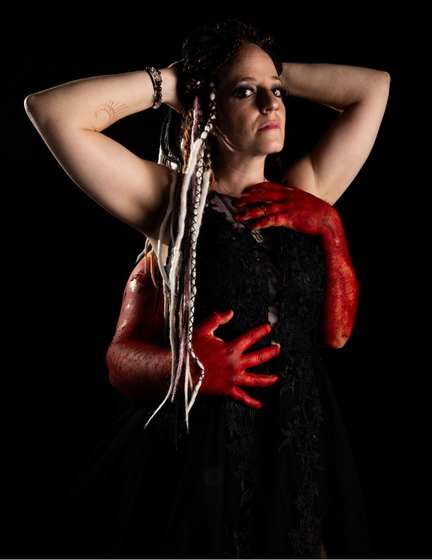 Dramatic portrait series featuring red lace and black fabric against dark background.