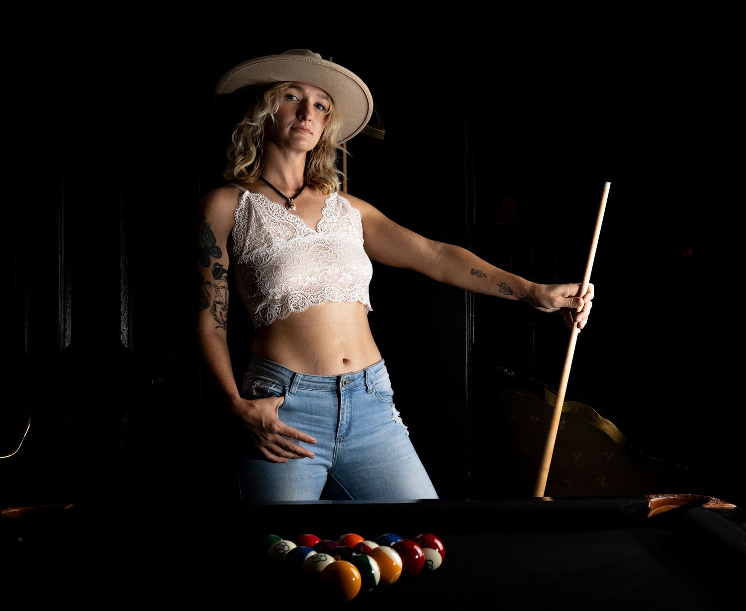 Western themed portrait series with hat and casual attire against dark background.