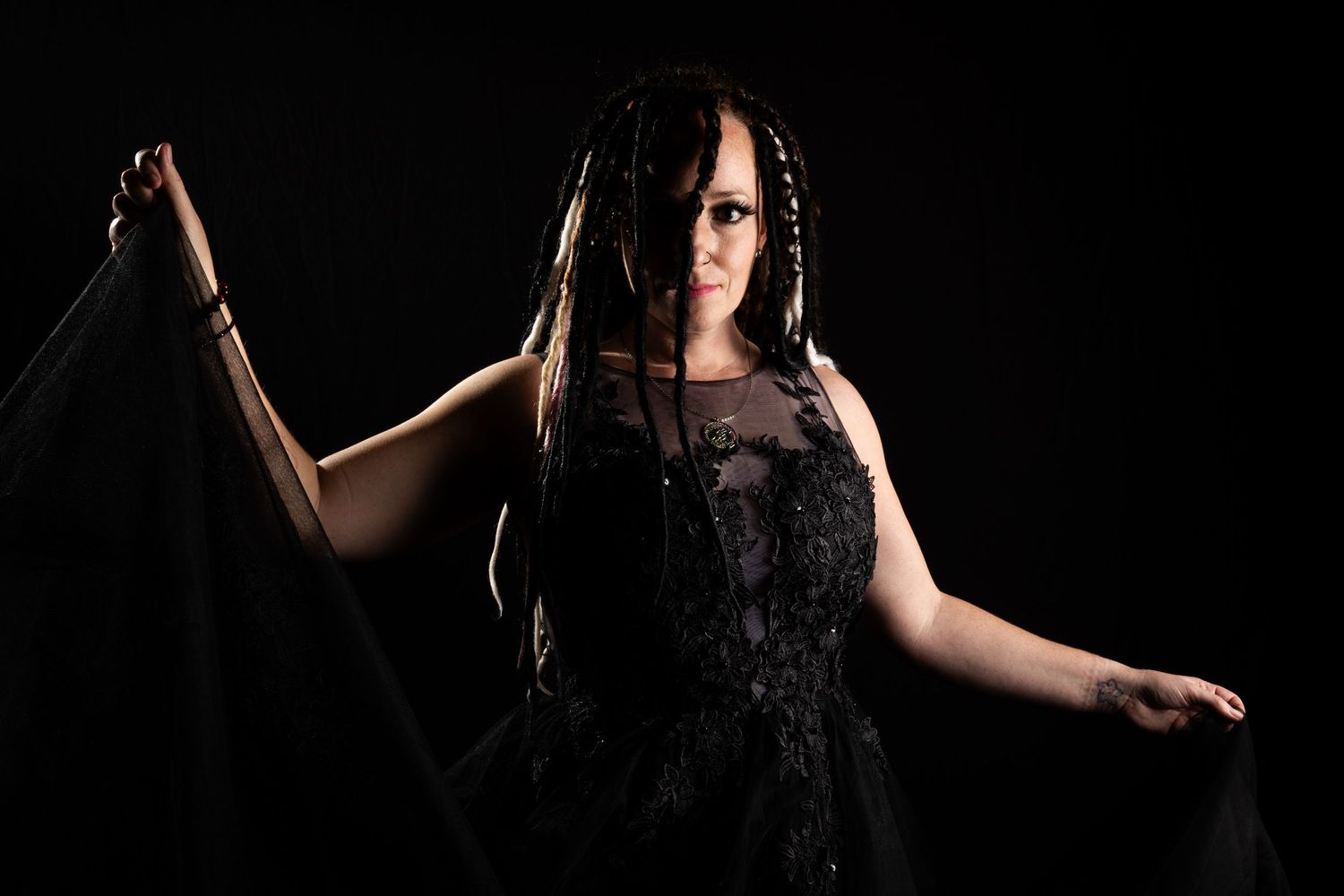 Dramatic portrait series in black outfit with artistic lighting effects.