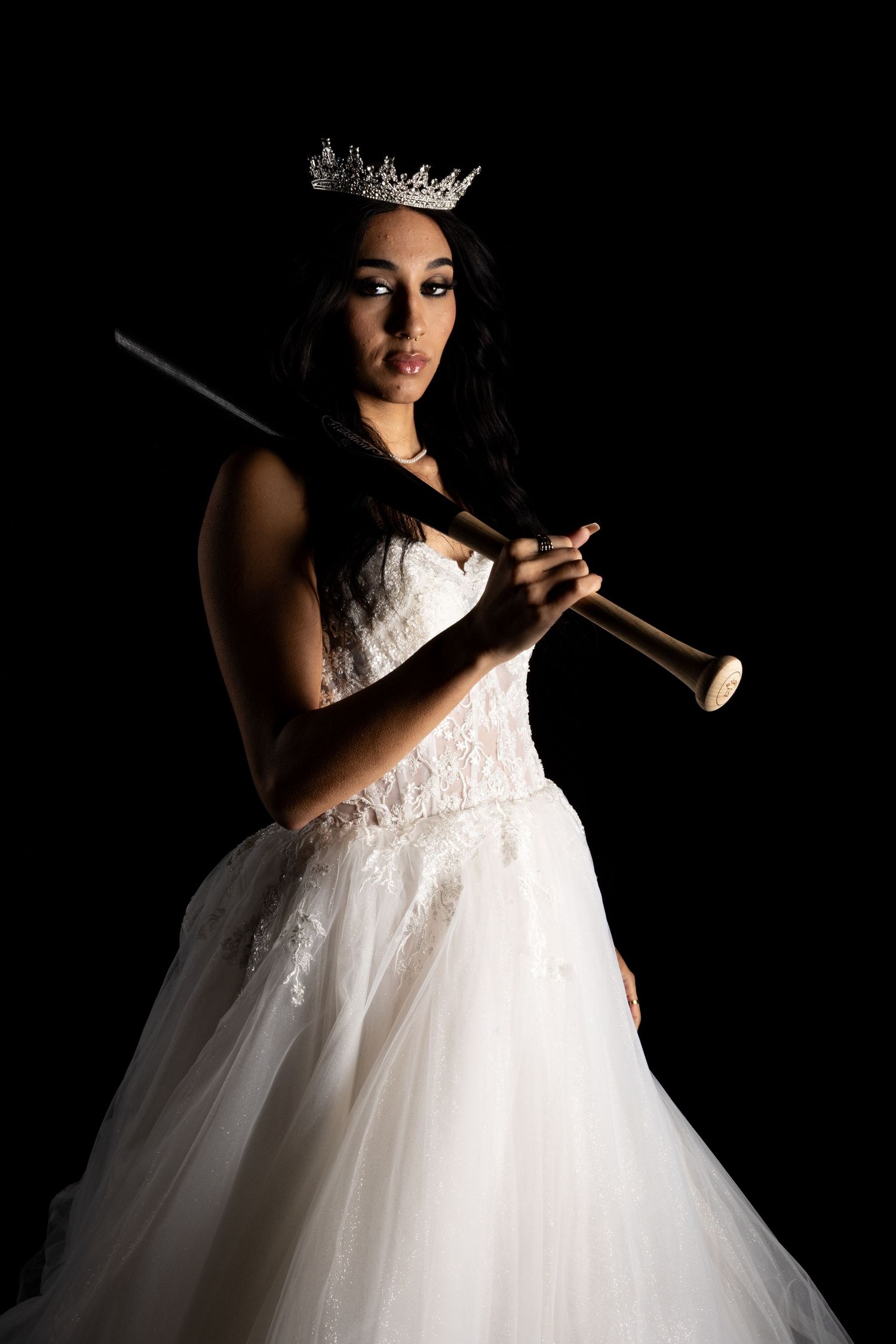 Silhouette photos of figure in white ballgown and crown against dark background.
