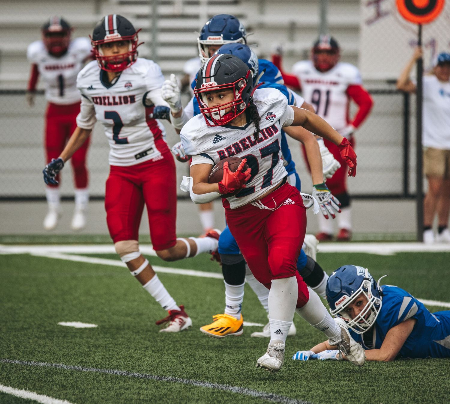 Football players collide during a tackle attempt on the field during a high school football game.