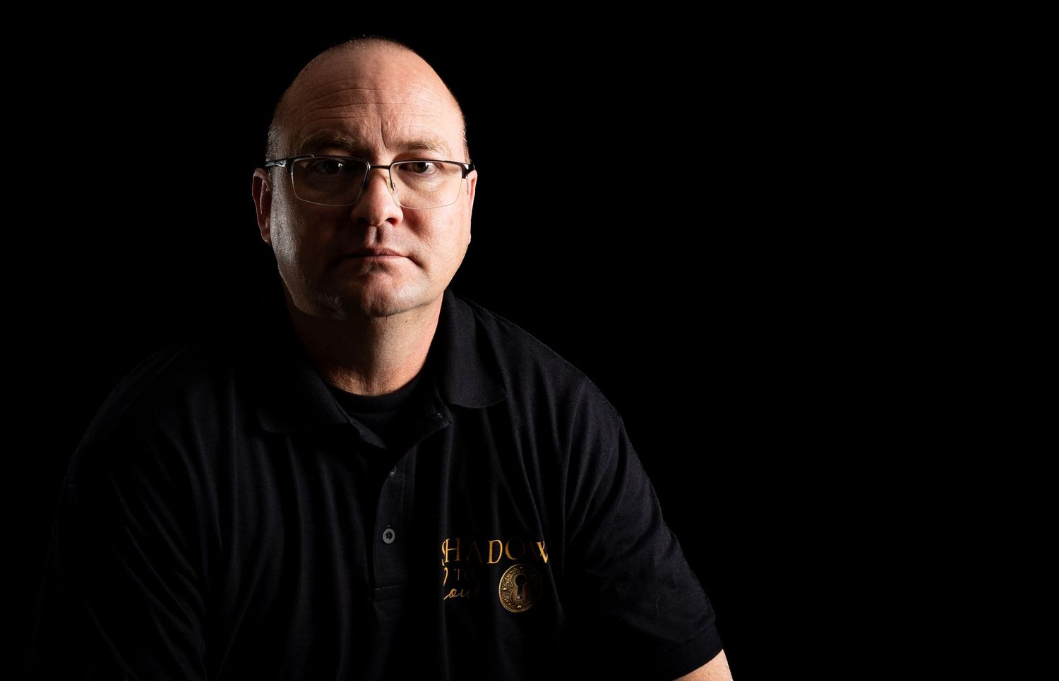 Professional headshot series of a person wearing glasses against dark background in dramatic lighting.