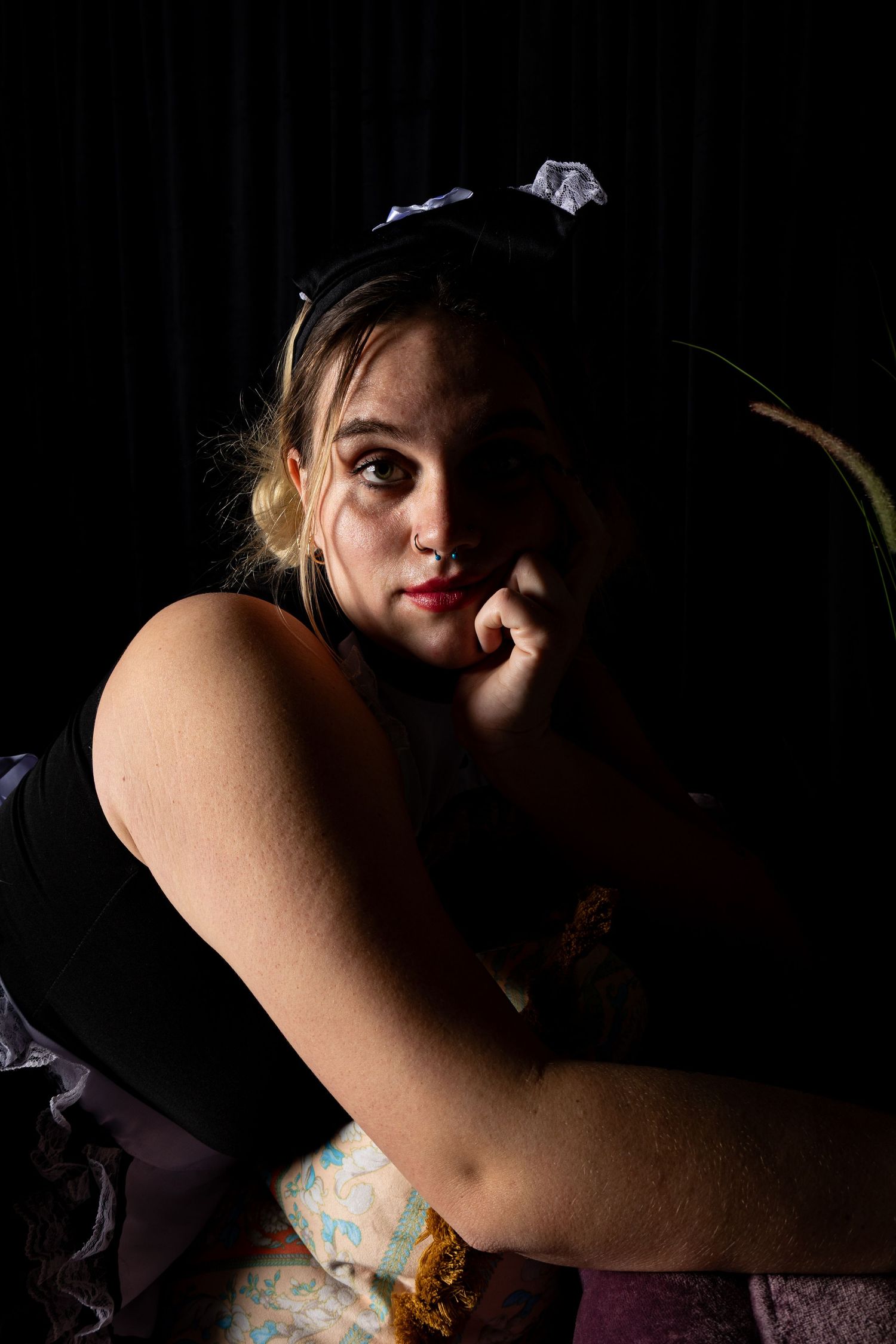 Intimate boudoir photography with dramatic lighting and shadows.