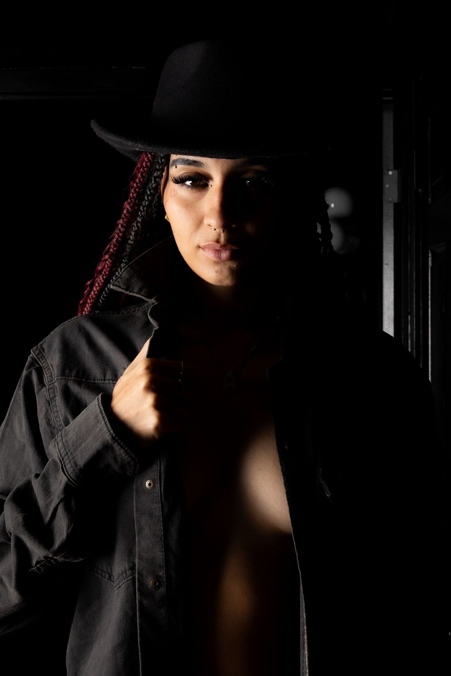 Noir-style portrait series featuring dramatic shadows and a black hat.