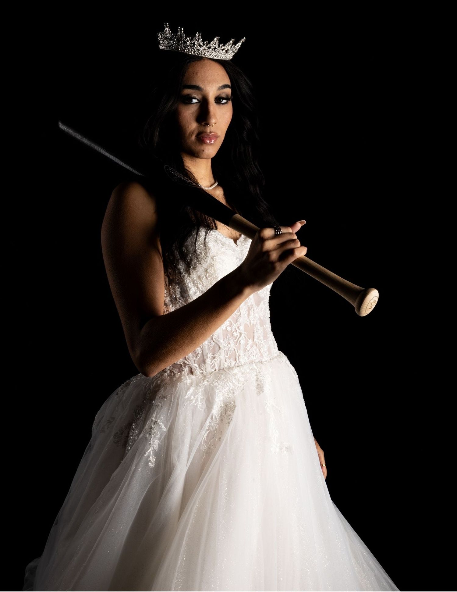 Dramatic low-key photography series showing a bride in a white gown against dark backgrounds.