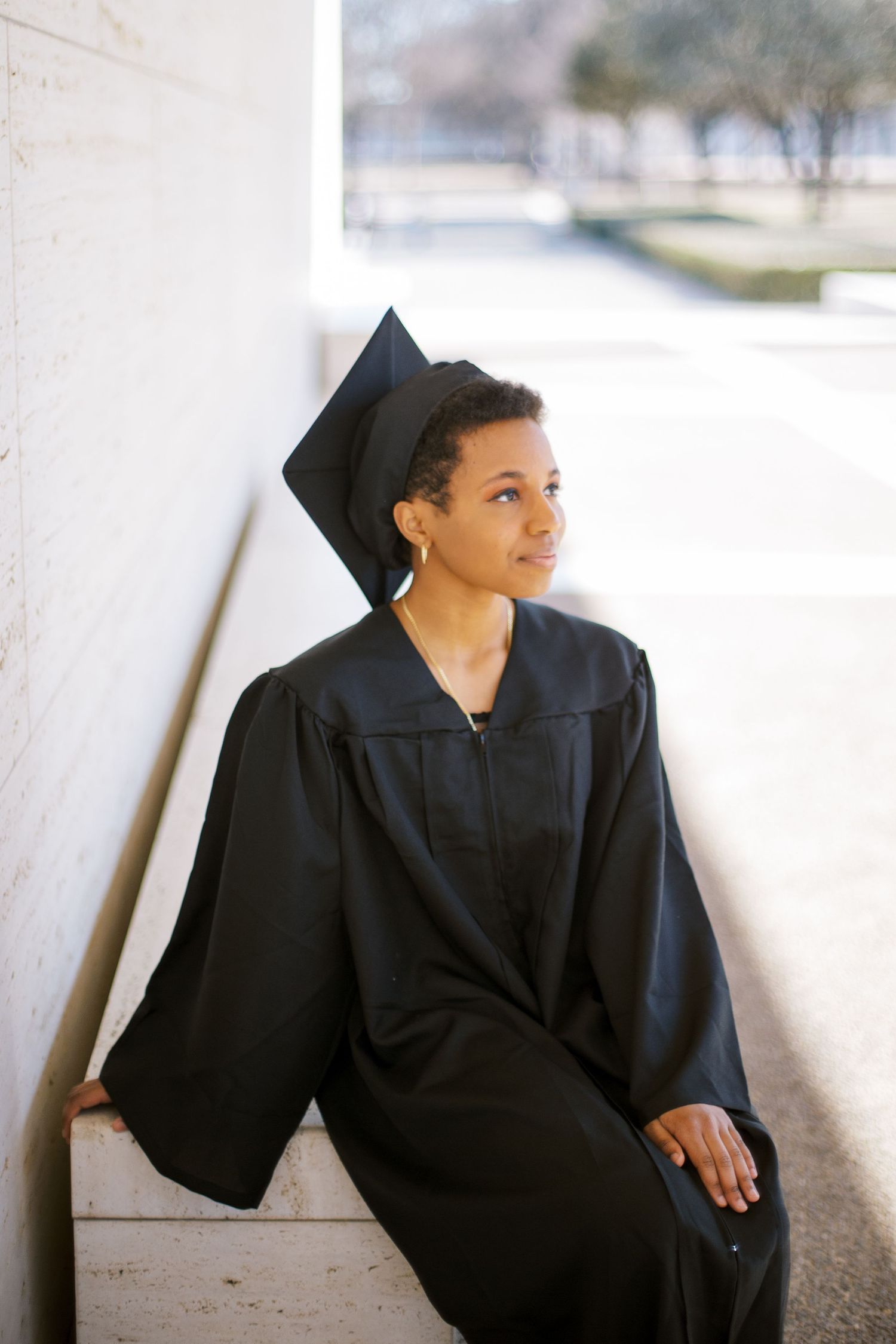 Senior portraits in downtown Fort Worth with urban textures and natural posing cap and gown