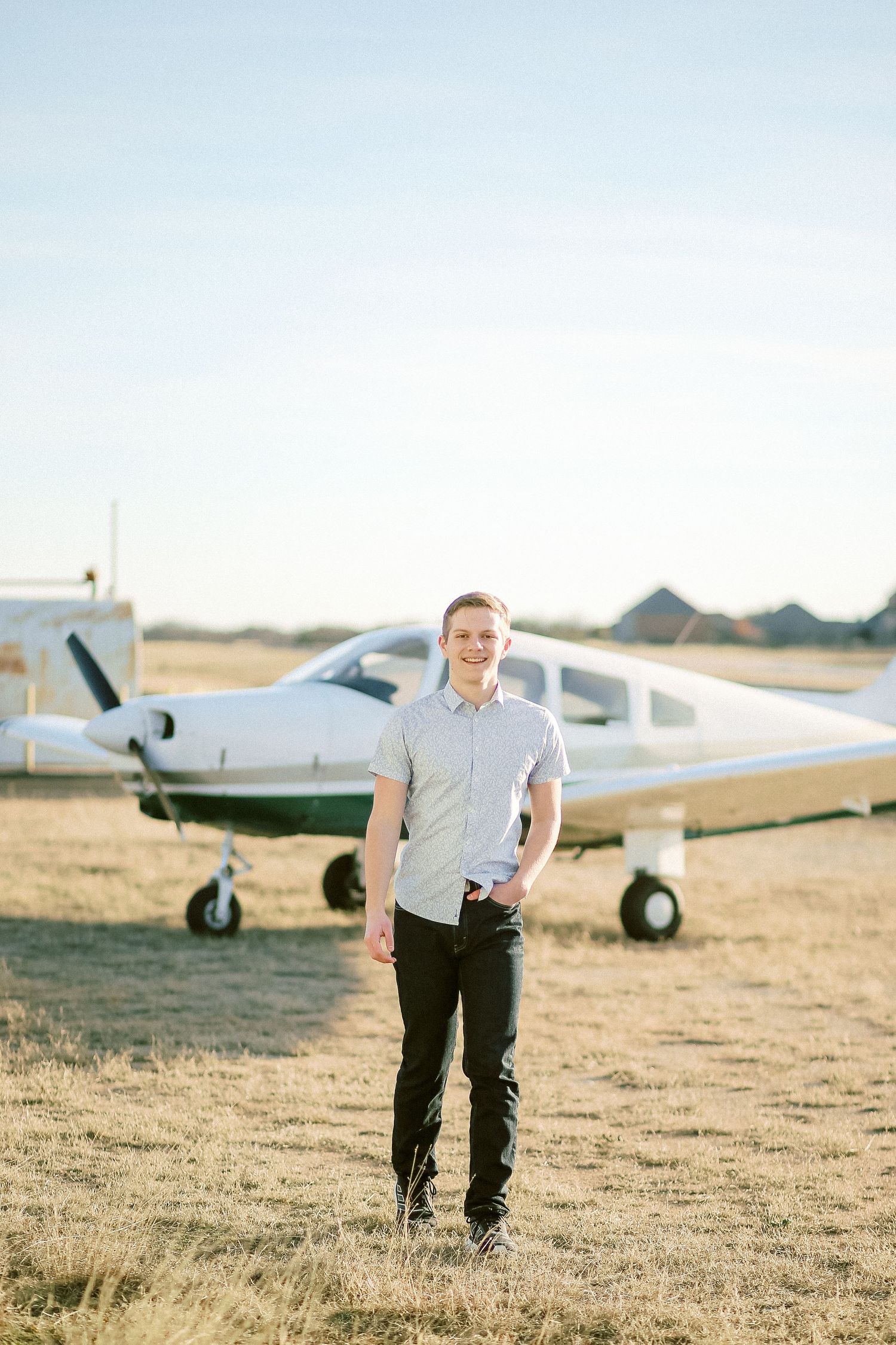 Senior boy portrait in downtown Fort Worth urban location airplane, at airport, plane senior portrait