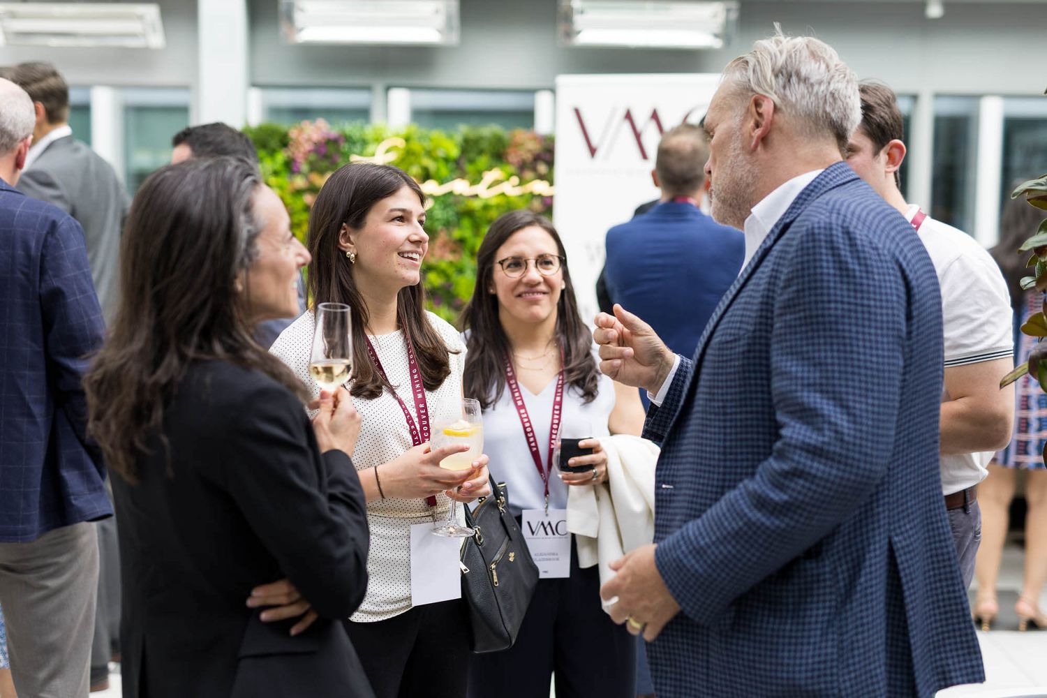 Group of professionals networking and conversing at an outdoor business event.