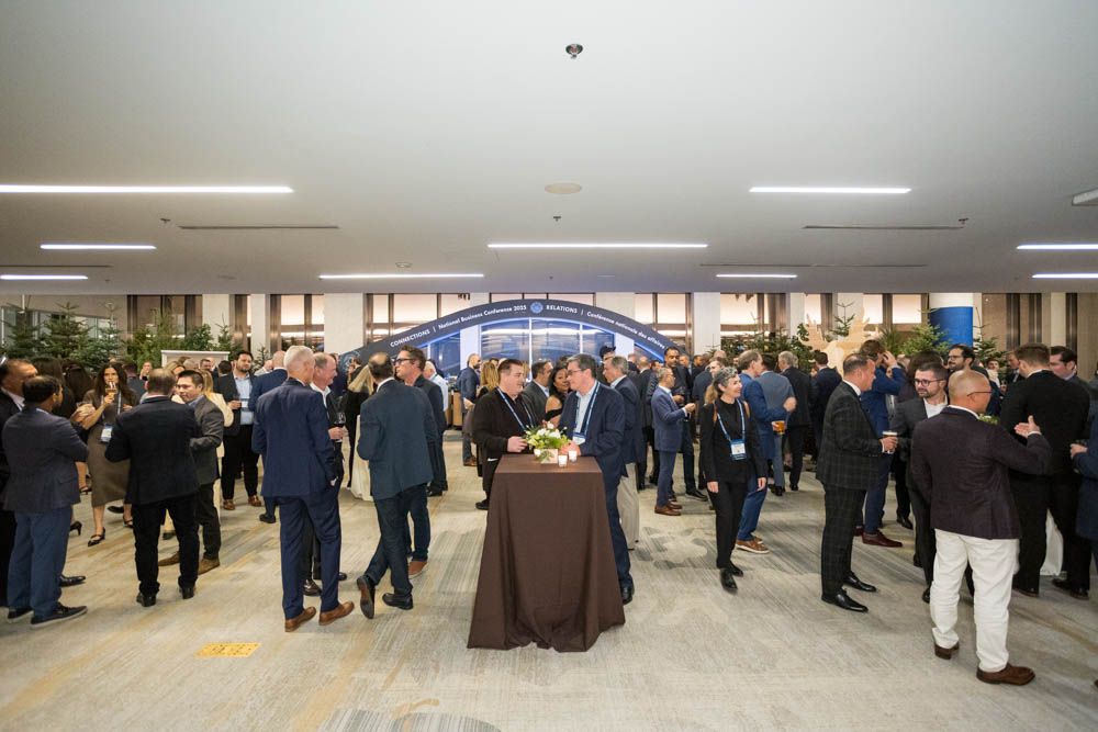 Professionals networking at a corporate event at the JW Marriott Parq Vancouver with elegant lighting and floral centerpieces.