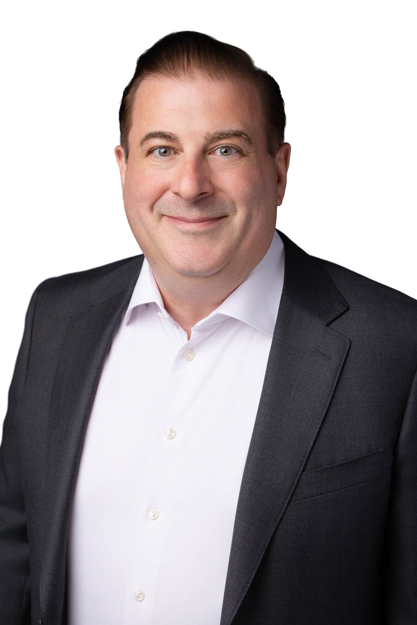 Professional headshot of a smiling middle-aged man in a dark blazer and white shirt against a white background.