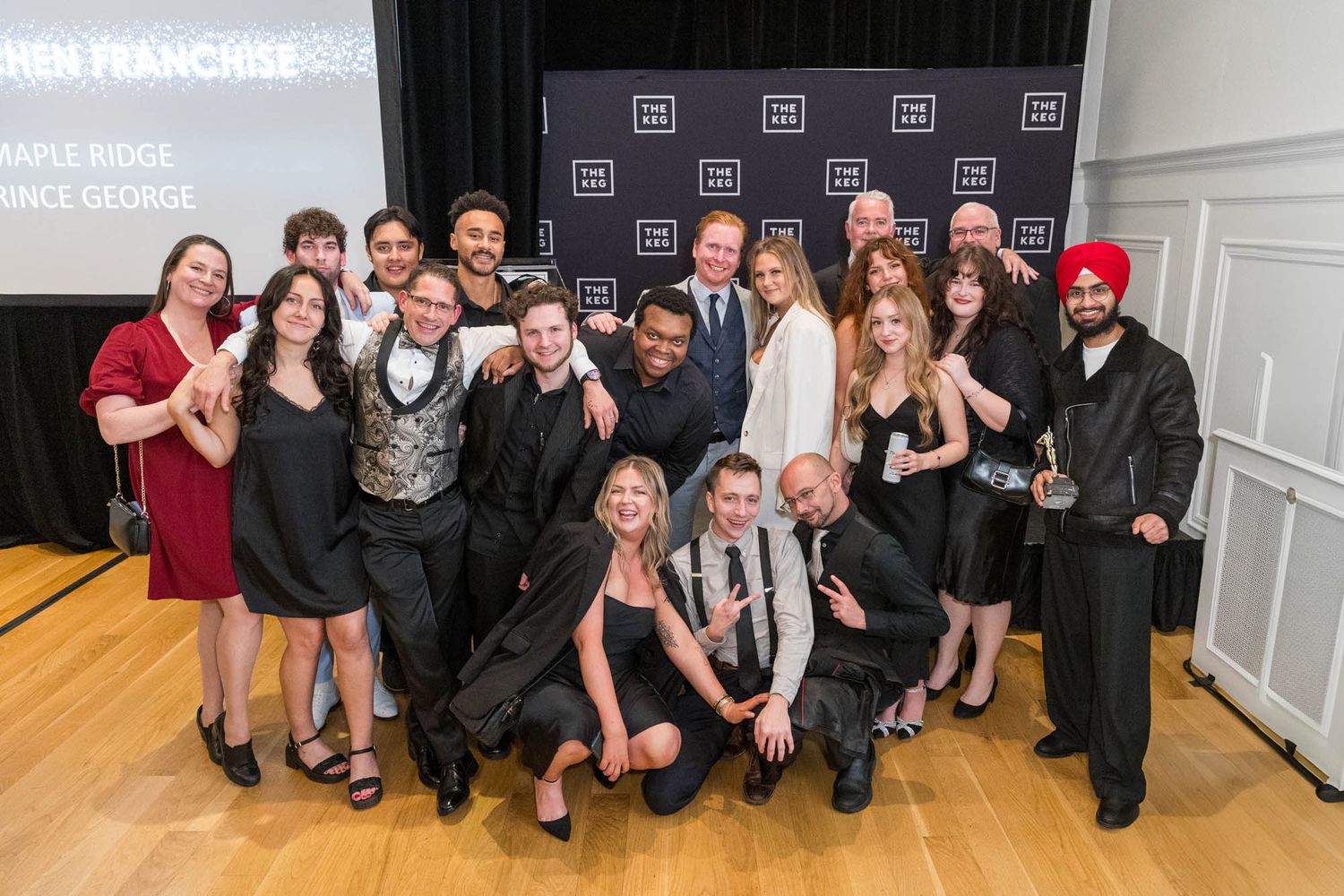 Group of award winners posing together at HEN Franchise 2023 event, representing Maple Ridge and Prince George locations.