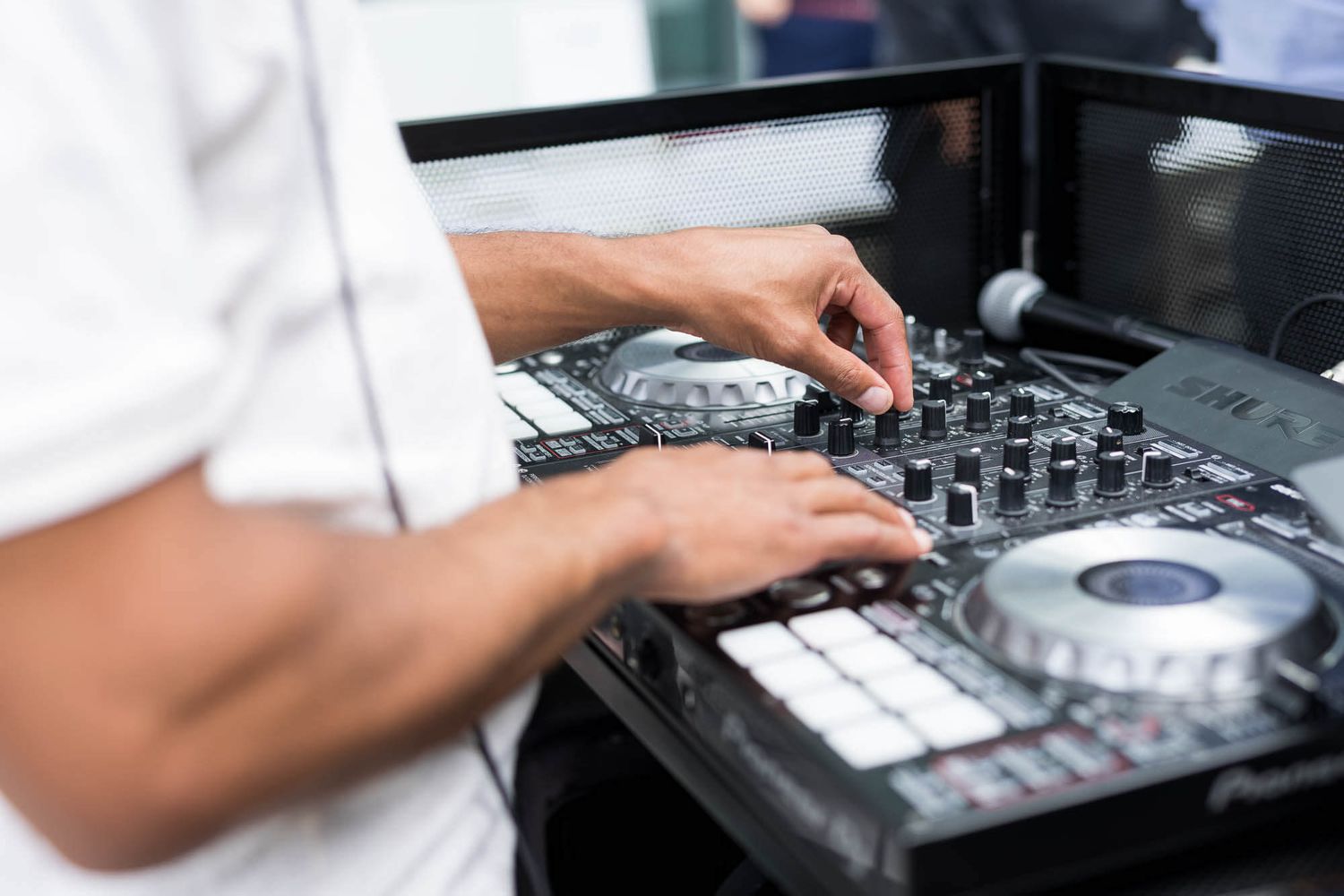 DJ mixing music on a professional turntable controller at an event.